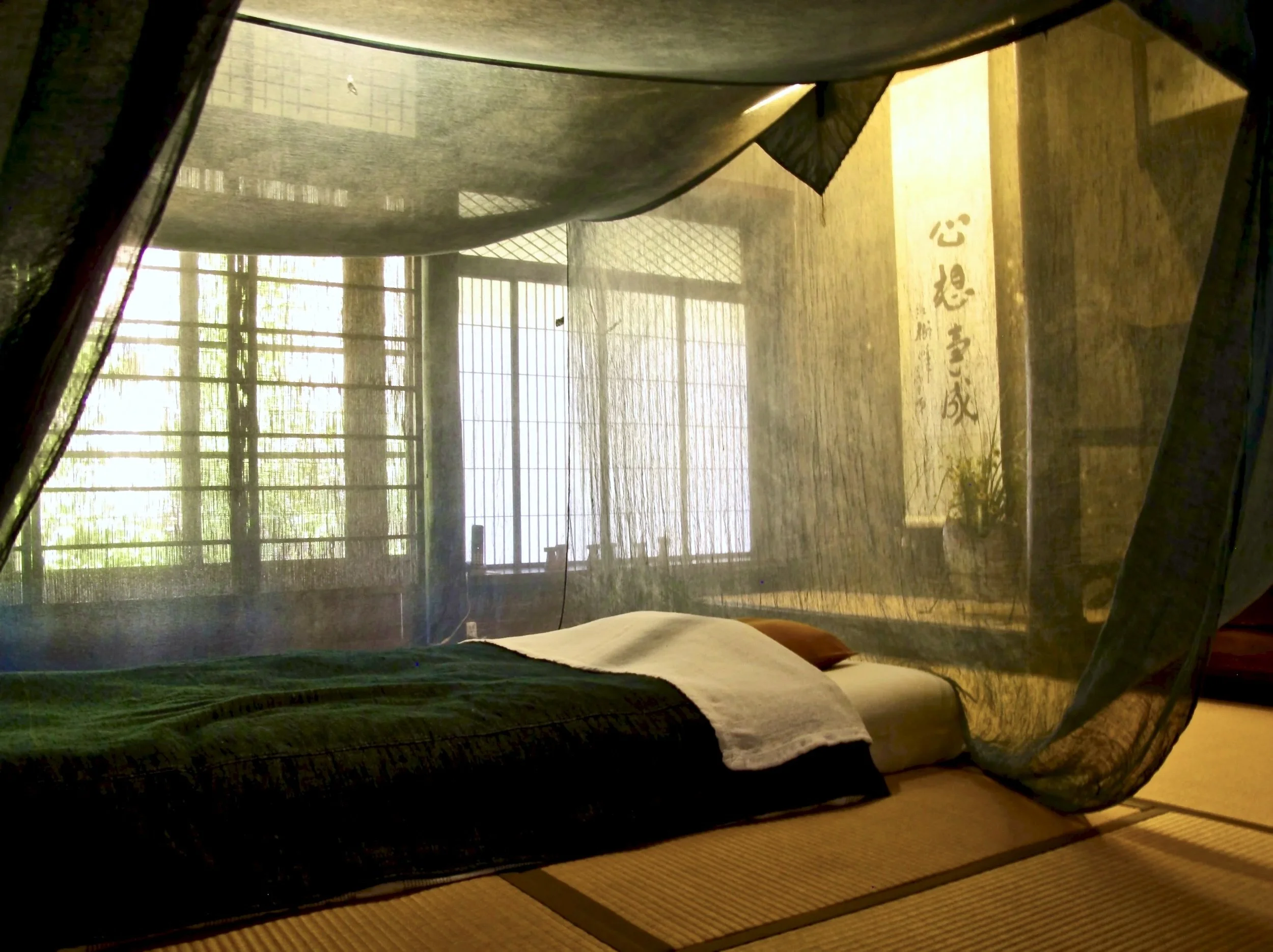 Bedroom at Takyo Abeke with indigo mosquito net over bed
