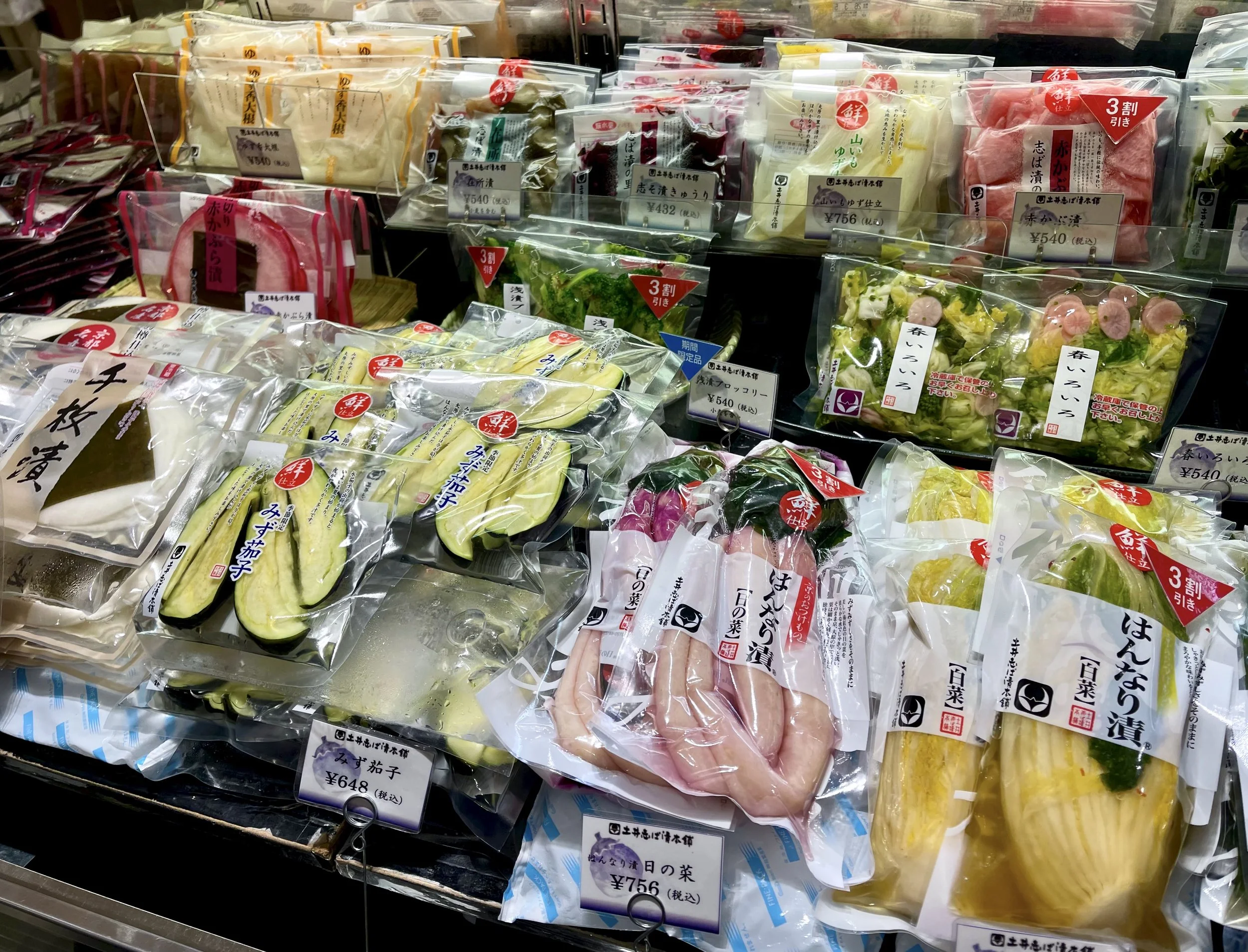 A wide assortment of tsukemono—Japanese pickles in many colors, shapes, and vegetables—displayed at a department store food counter