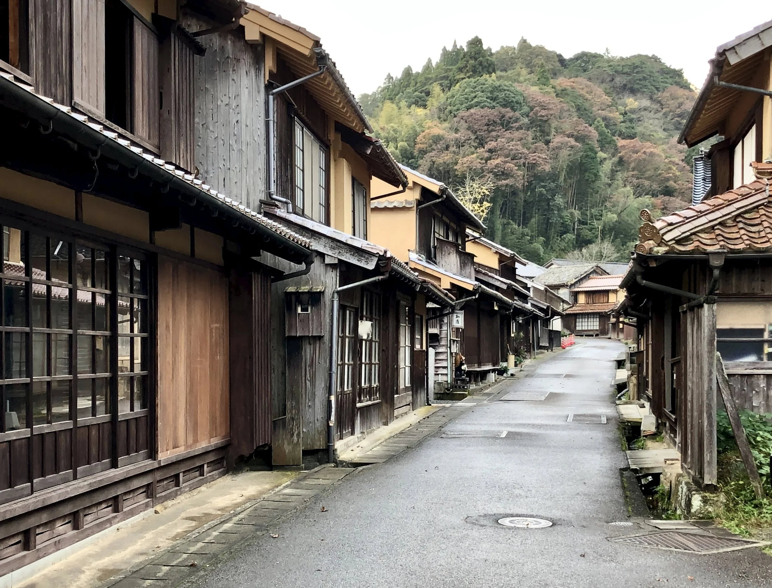 Main road through Omori village with traditional houses along a mountain stream in Shimane