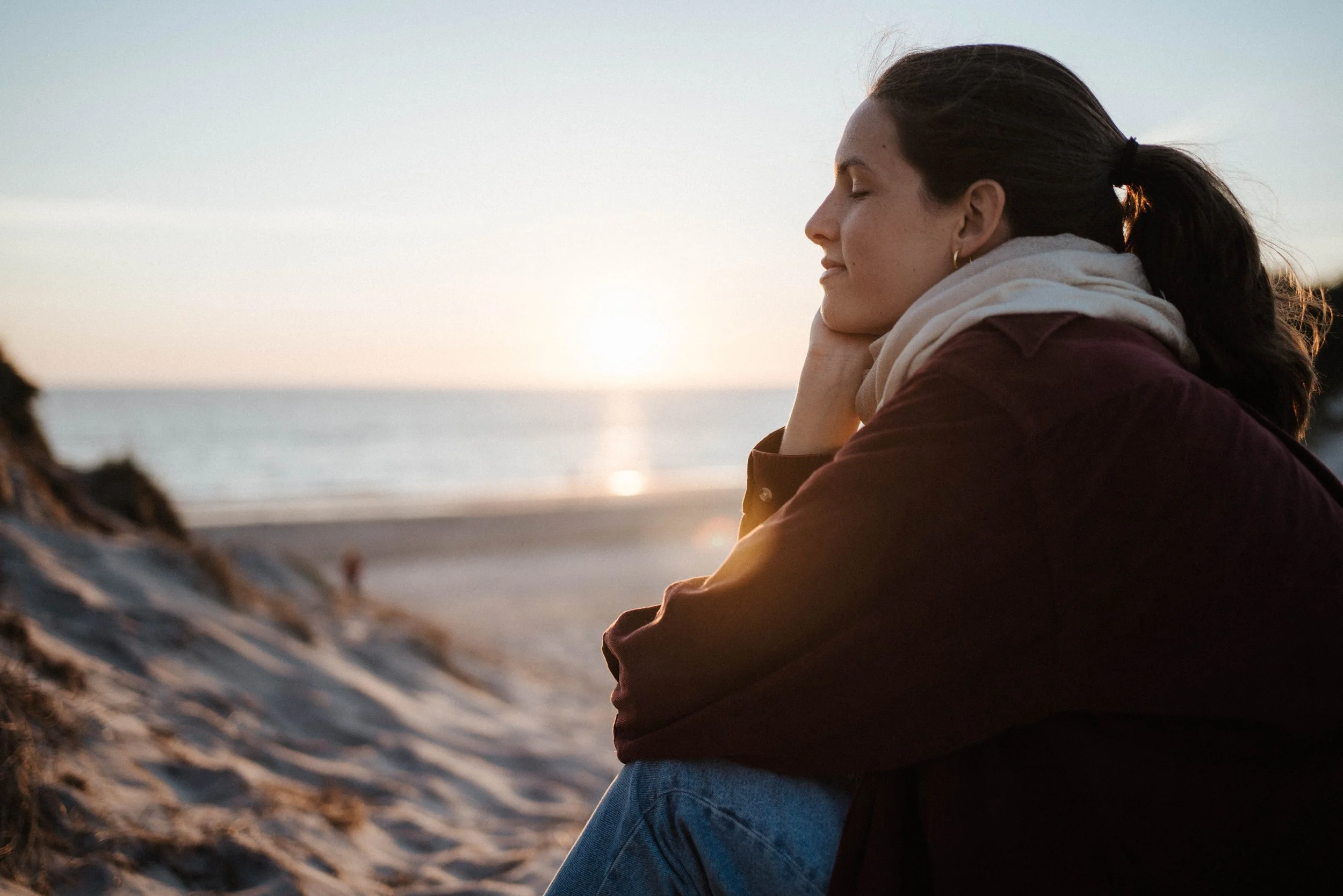 Frau entspannt am Strand bei Sonnenuntergang