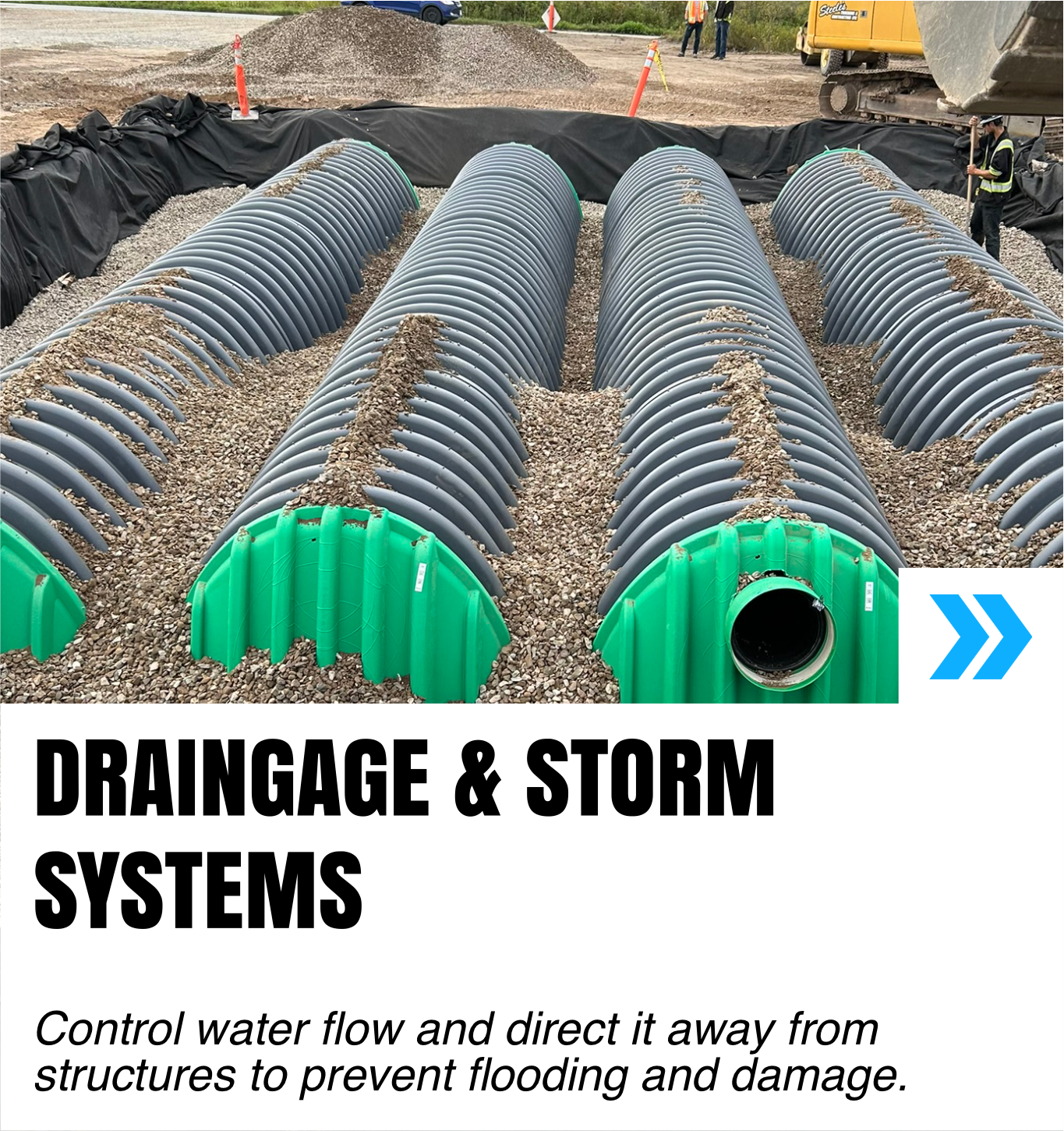 Construction site showing large underground drainage pipes with green protective caps, laid in trenches with gravel bedding for stormwater management.