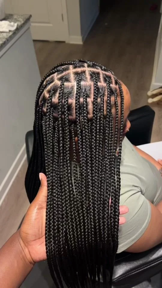 The Minimalist Knotless Silhouette
Name: The Artisan Knotless

Description: "Our masterclass in precision. By utilizing a knotless technique, we prioritize scalp health and a natural fall from the root. This silhouette is defined by its clean parting