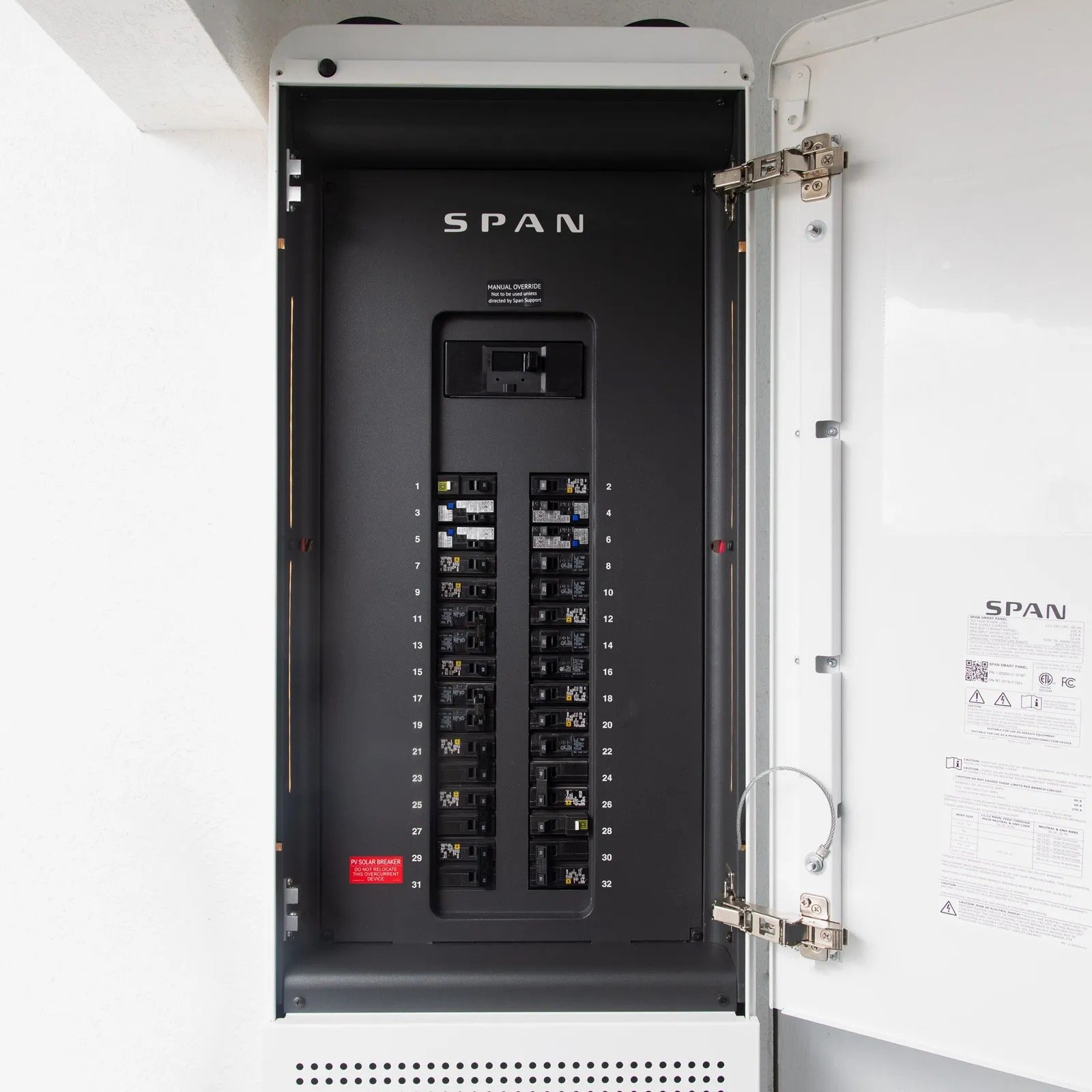 Open electrical breaker panel with multiple circuit breakers and a label indicating it is a SPAN panel.