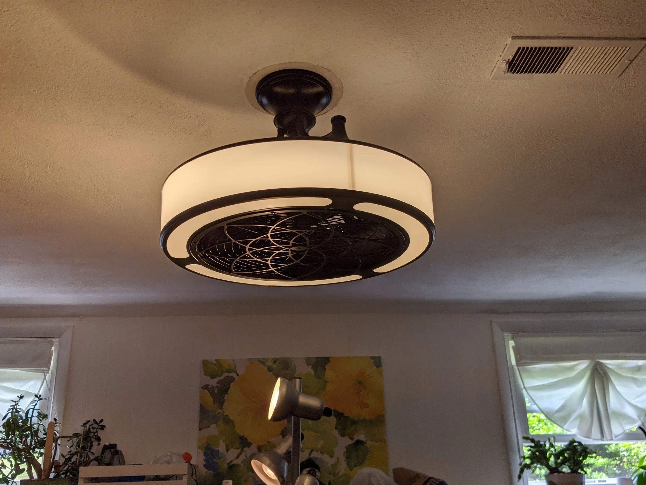 Indoor ceiling fan with a light fixture and a decorative fan design in black and beige