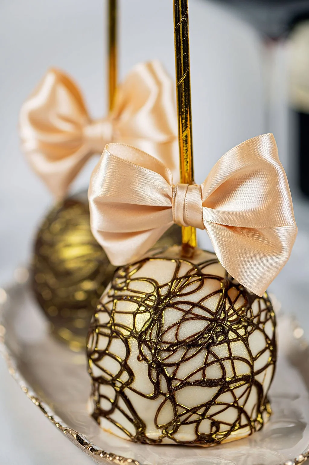 Decorative Christmas ornaments with satin bows and gold accents on a silver tray.