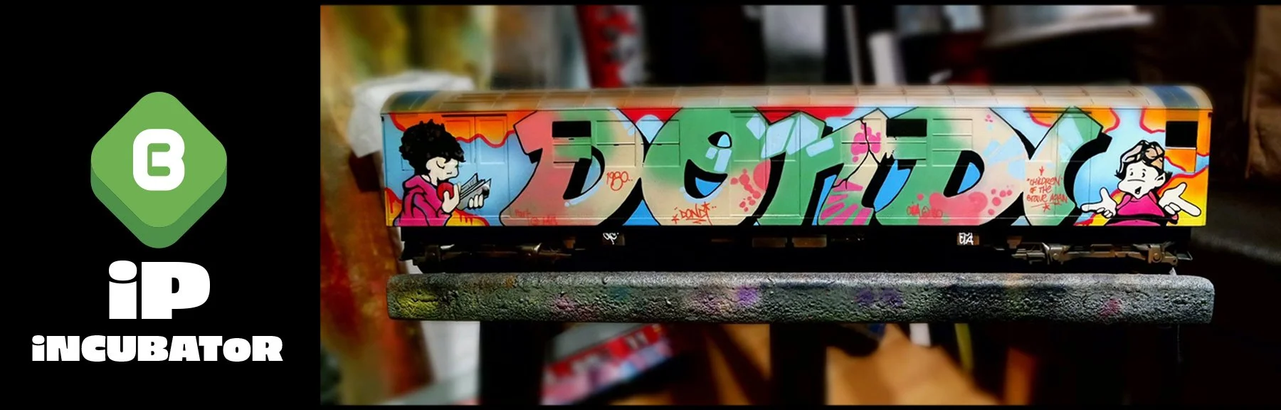 Graffiti-covered train car on a model railway with cartoon characters on the sides.