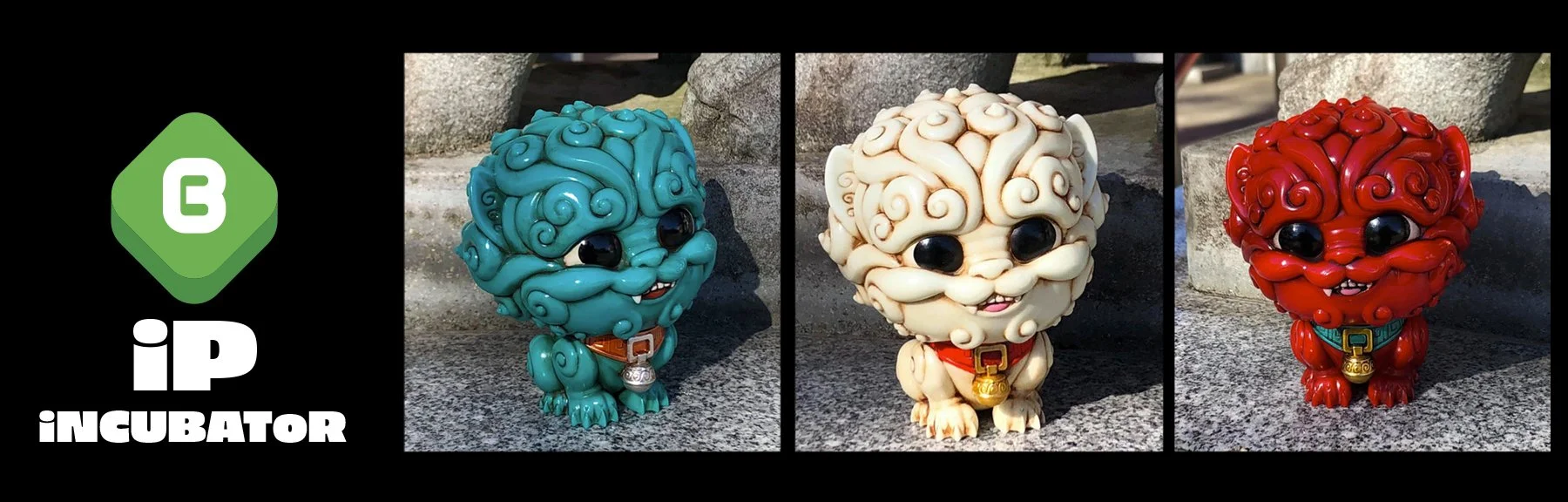 Three stylized lion figurines in different colors (blue, cream, red) with curly fur, large black eyes, and collar with bell, set outdoors on a textured stone surface.