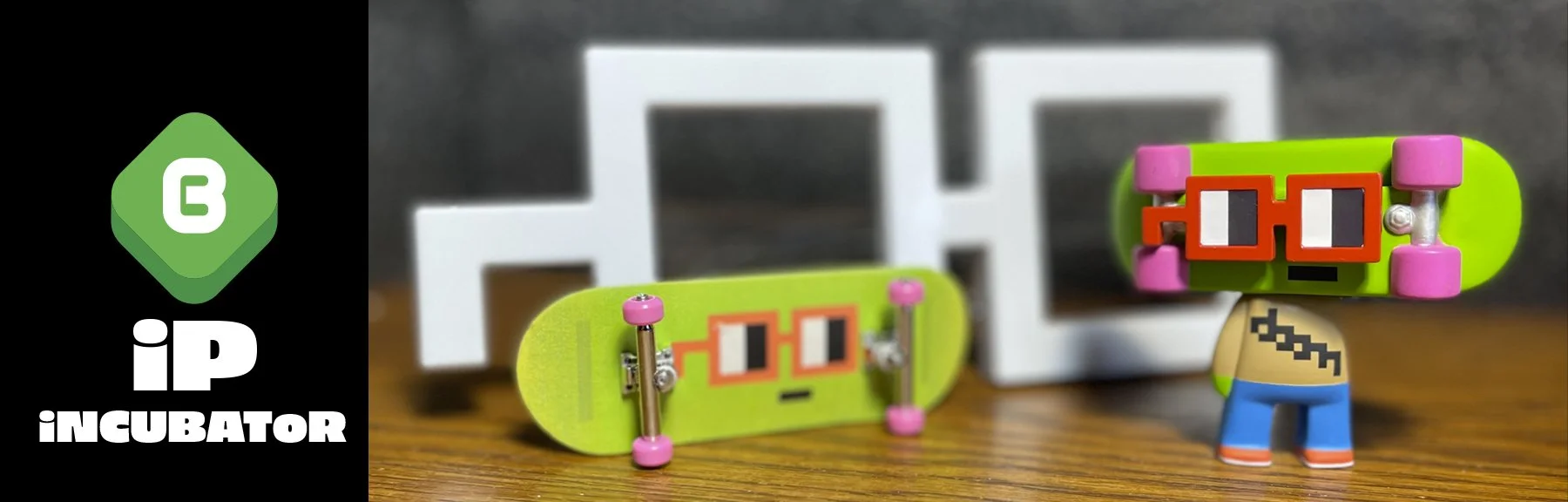 Two skateboards with pixelated animated faces, pink wheels, and red glasses, along with a small toy figure with a pixelated mask, set on a wooden surface with geometric white decor in the background.