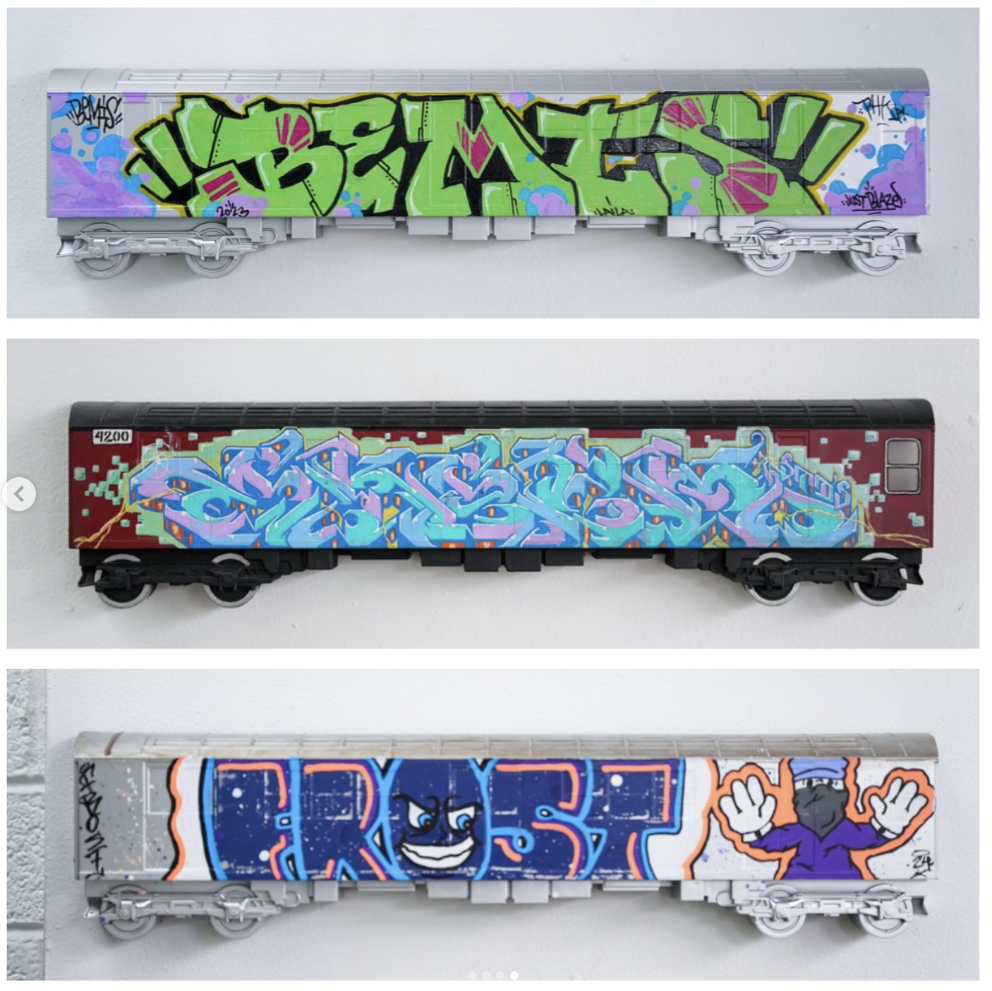 Three model trains with graffiti art, each with different colorful graffiti designs on the sides.