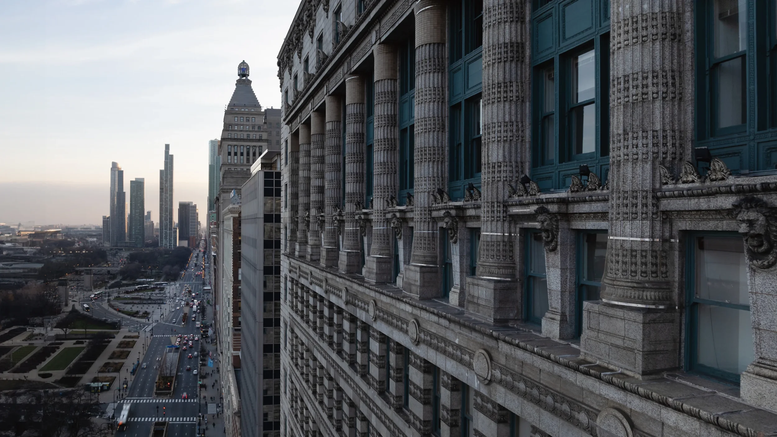 Cityscape featuring a historic building with ornate architectural details and modern skyscrapers in the background during daytime.