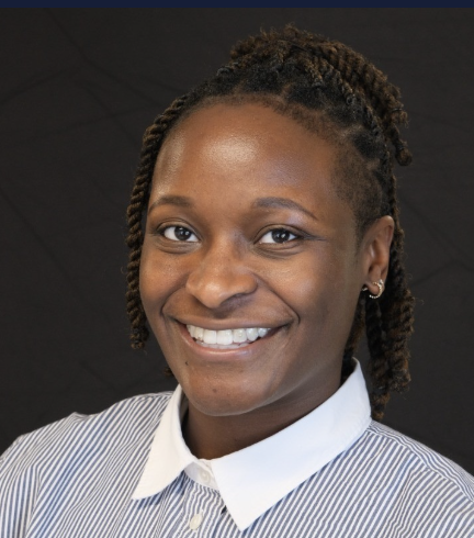 Young woman smiling with natural hair in twists, wearing a white collared shirt against a dark background.
