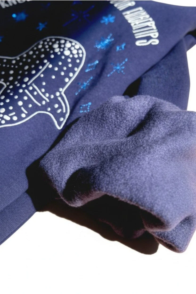 Close up macro shot of soft plush fleece inner lining turned out on sleeve cuff of dark navy hoodie