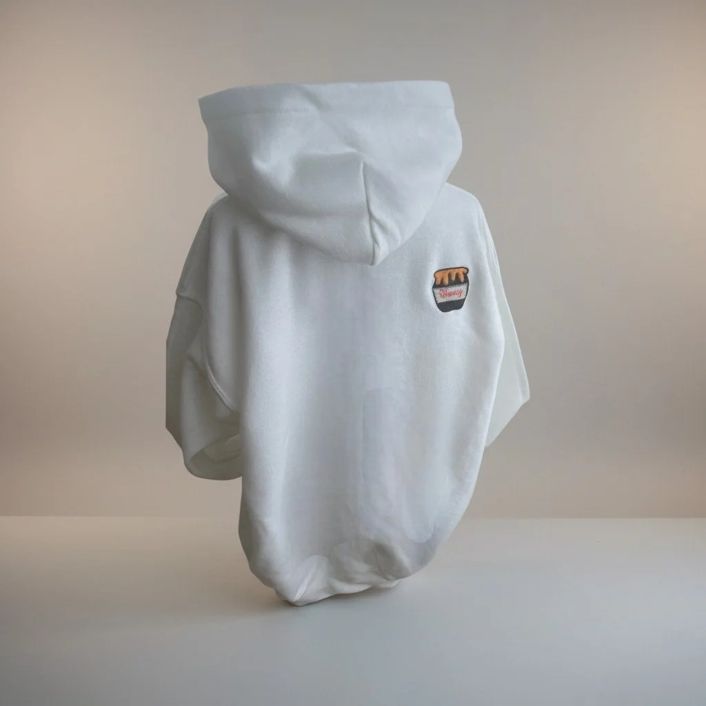 A white hoodie with a small embroidered graphic of a jar of honey on the back.