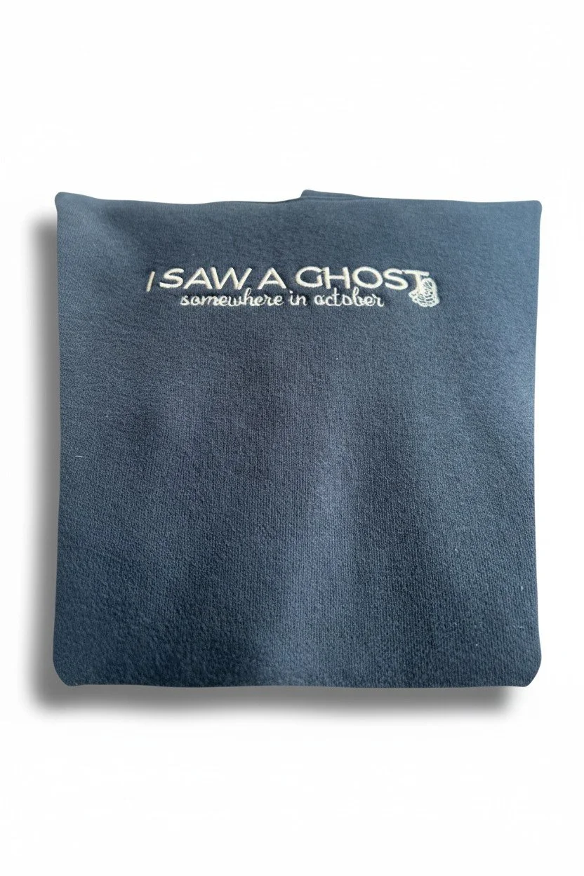 Close-up of embroidered Halloween hoodie front reading “I SAW A GHOST” with “somewhere in October” underneath.