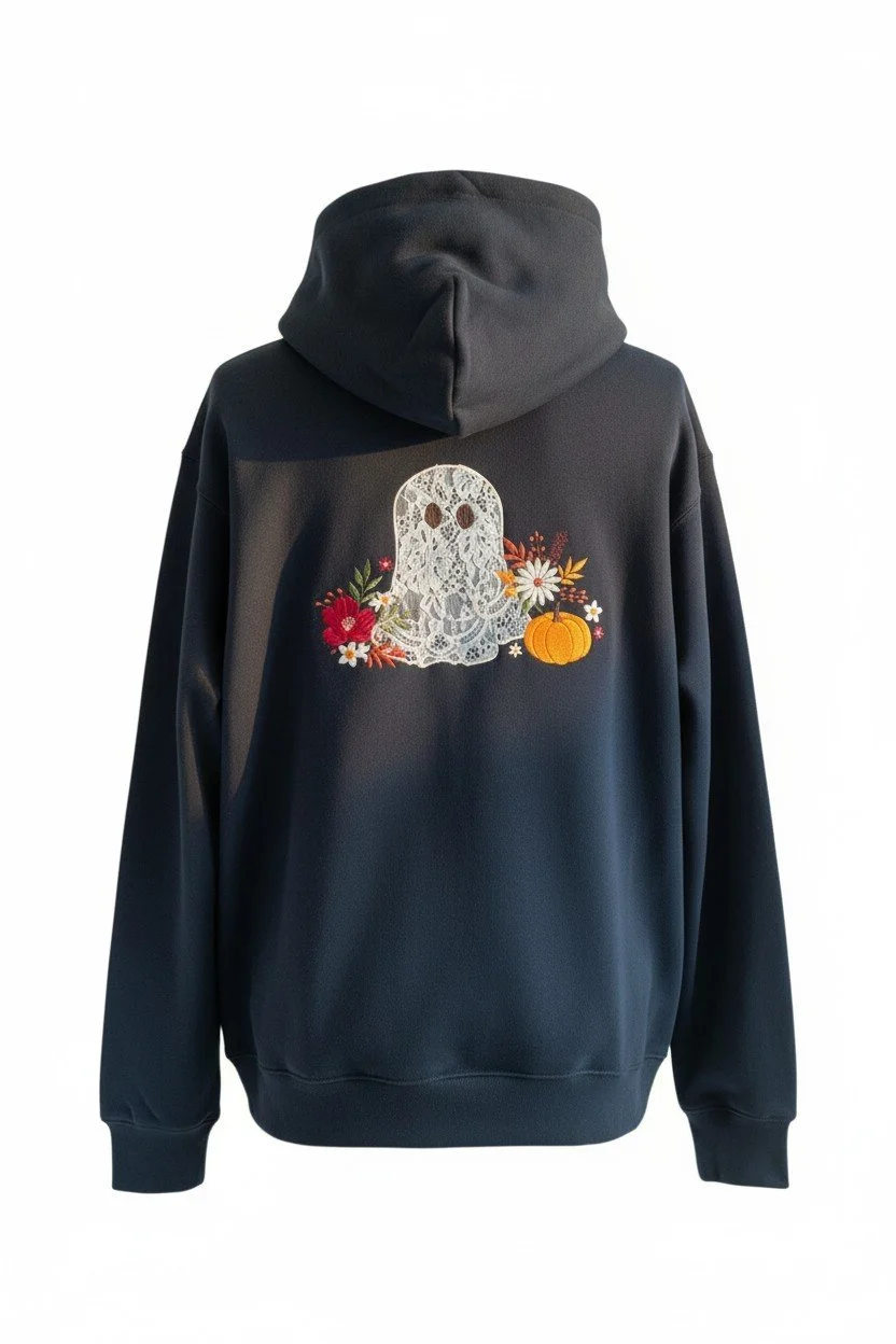 Detailed embroidered lace ghost surrounded by fall flowers and pumpkins on black Halloween hoodie.