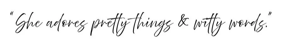 Quote in black cursive handwriting that says "She adores pretty things & witty words."