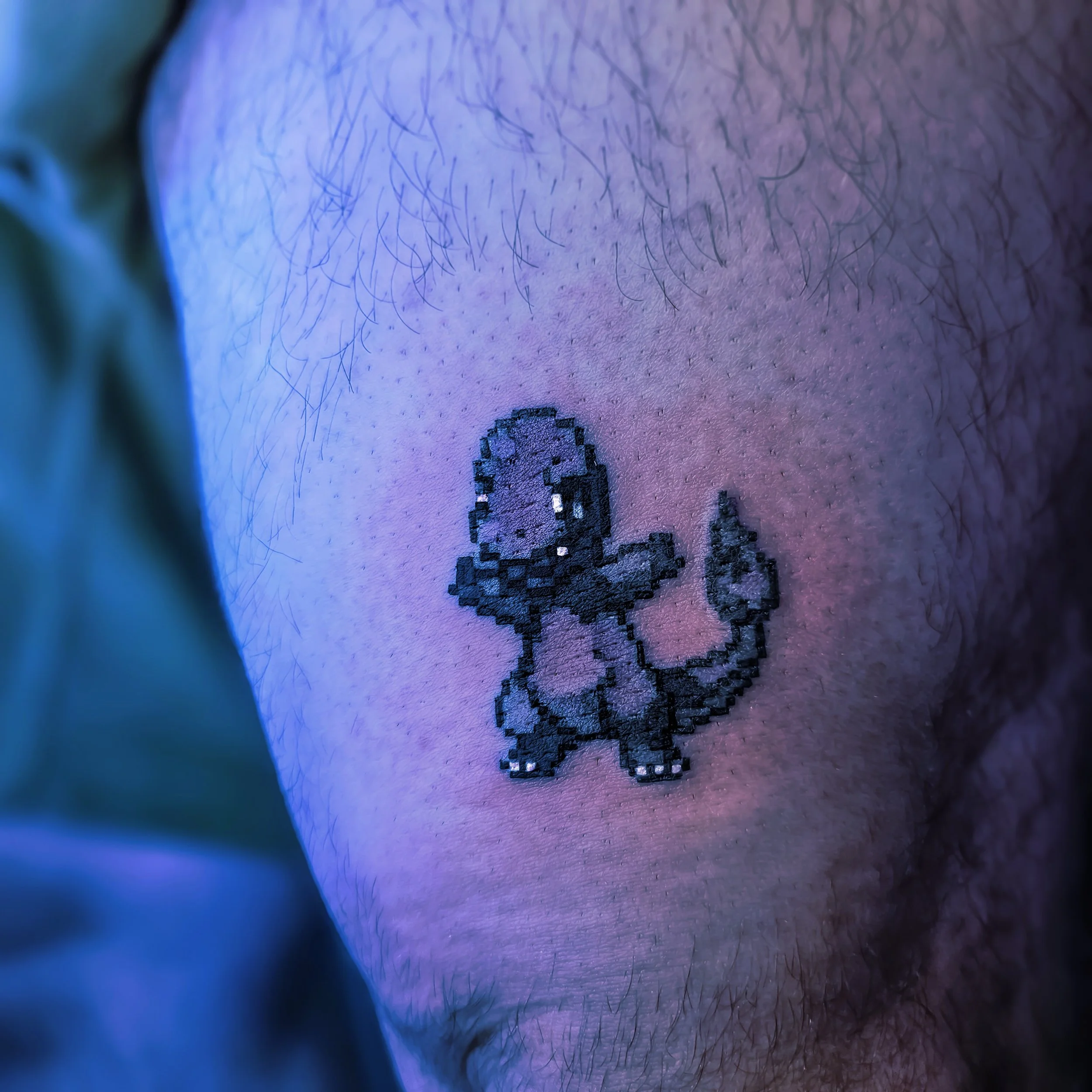 Pixel art tattoo of a small dinosaur on skin with hair and purple lighting.