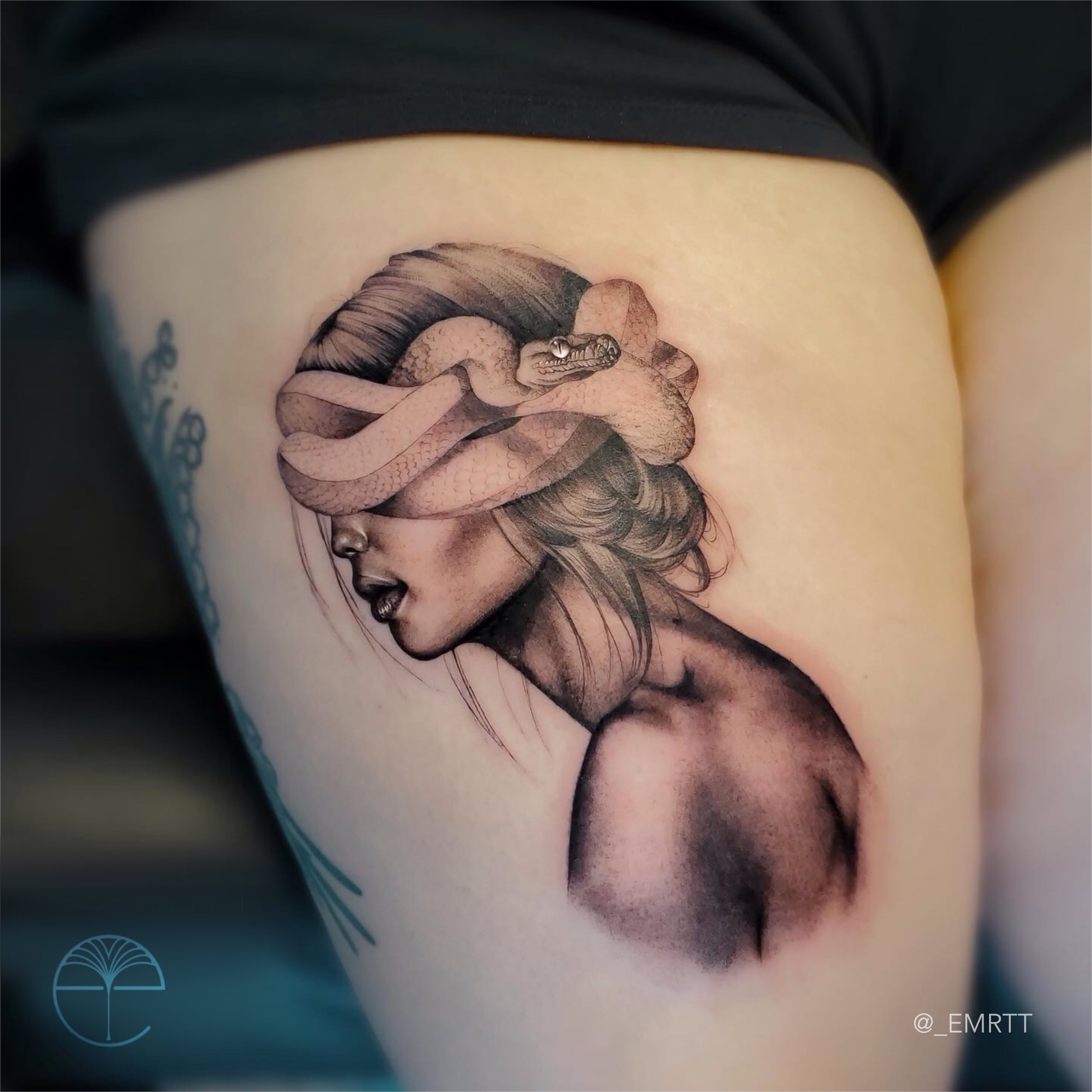 Tattoo of a woman with flowing hair and a snake wrapped around her head.