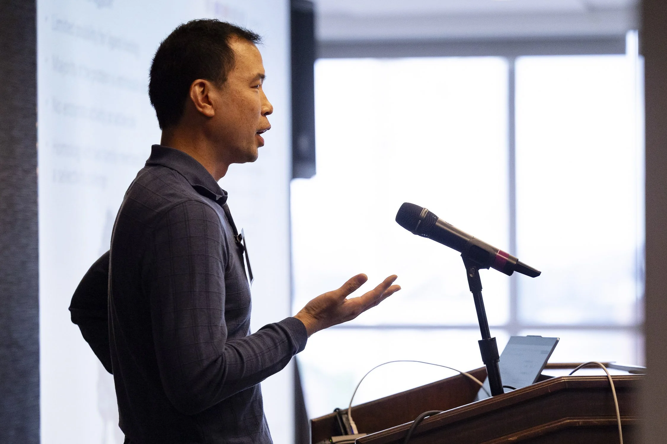 A man giving a presentation at a biotech conference at Mass General Hospital in Boston, MA.