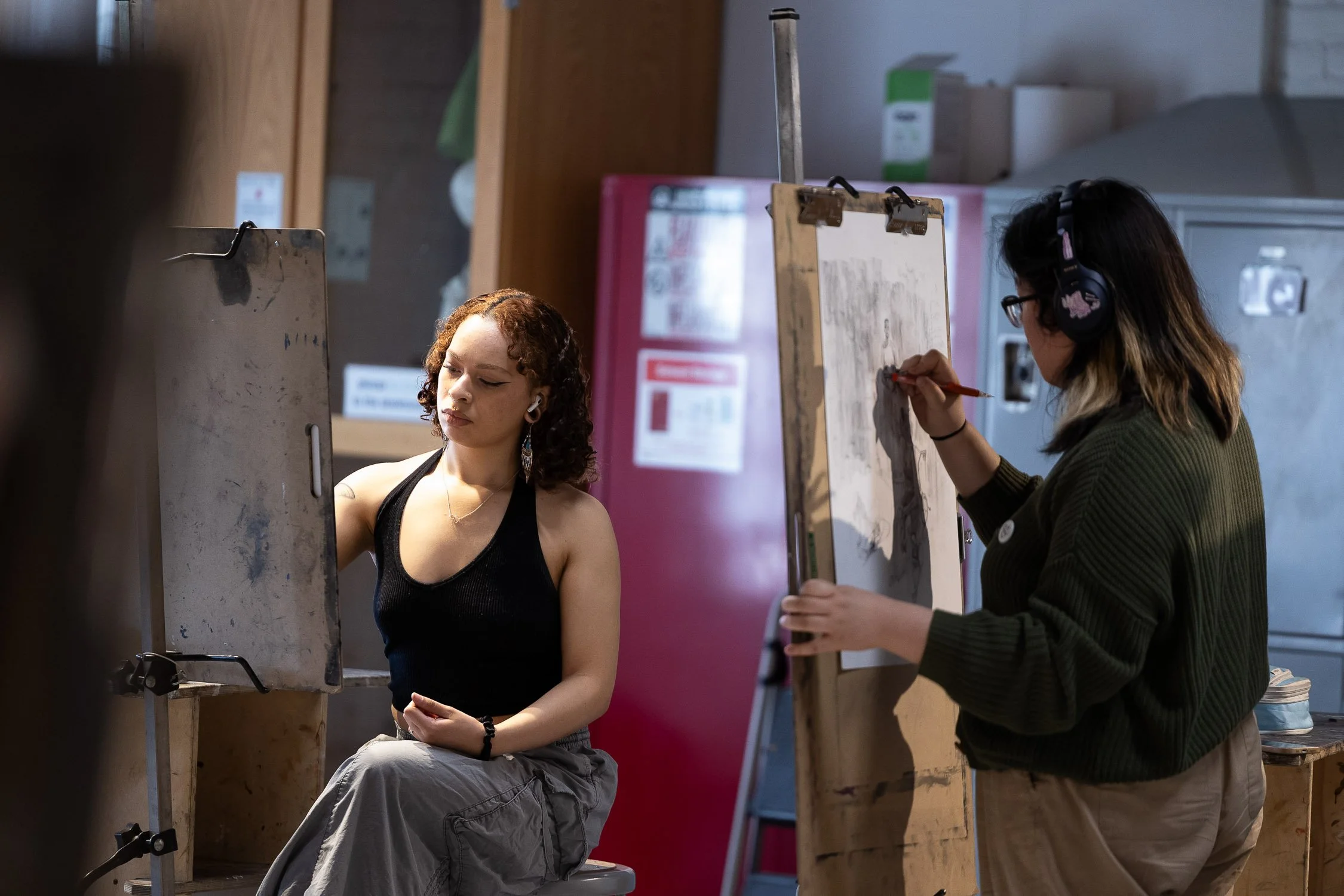 An art student is sitting in front of an easel at RISD.