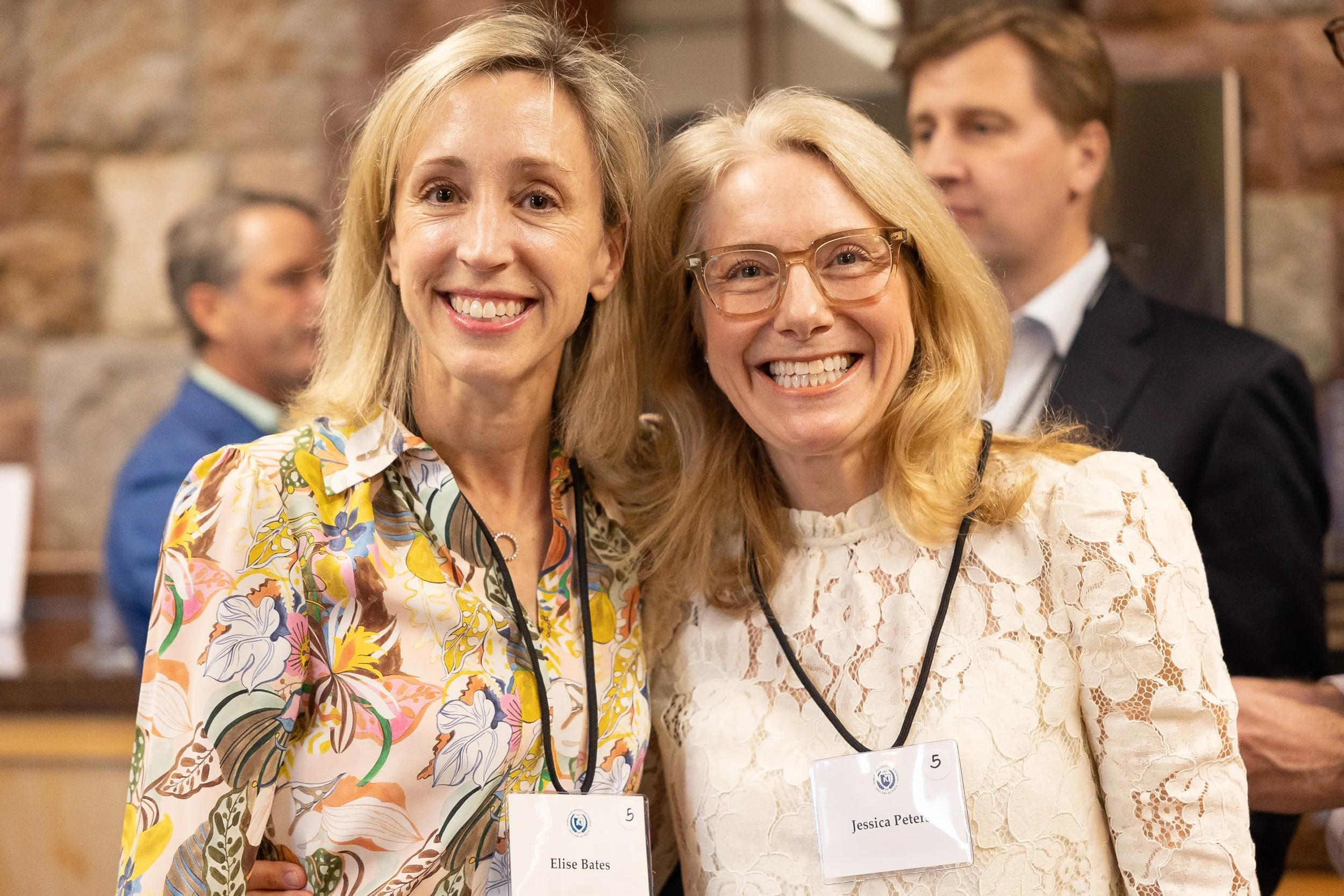 Two women smiling at a networking event at a private school in Massachusetts.