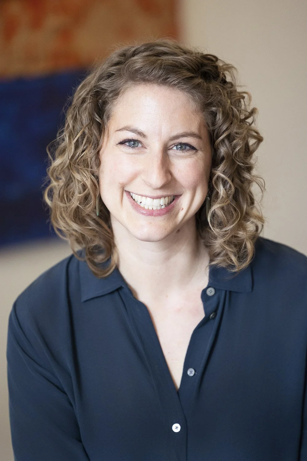 A female business owner with curly light brown hair at a coworking space in Boston, Massachusetts.
