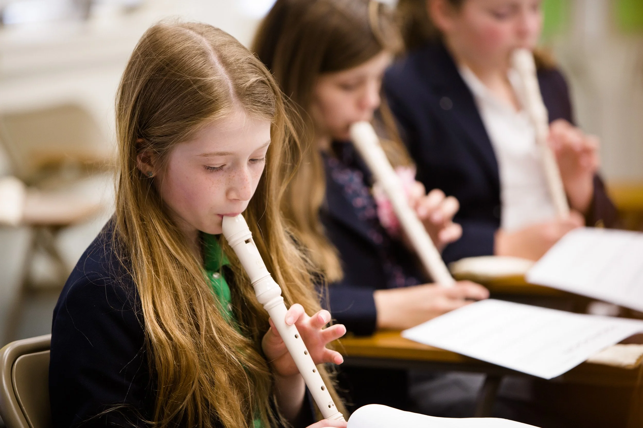Three students playing recorders during a music class at a Massachusetts private school.