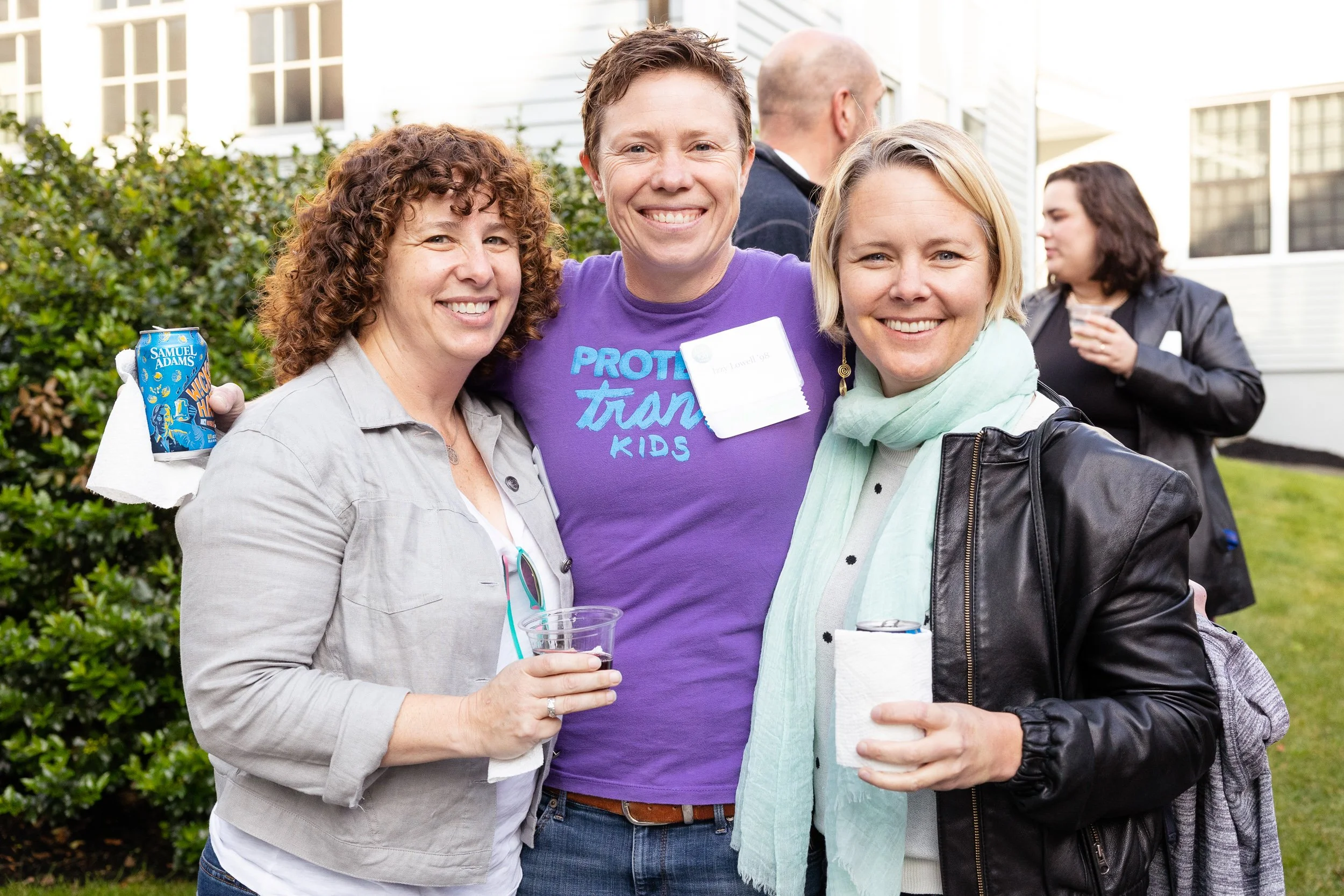 Three women smiling at a high school reunion at a Massachusetts independent school.
