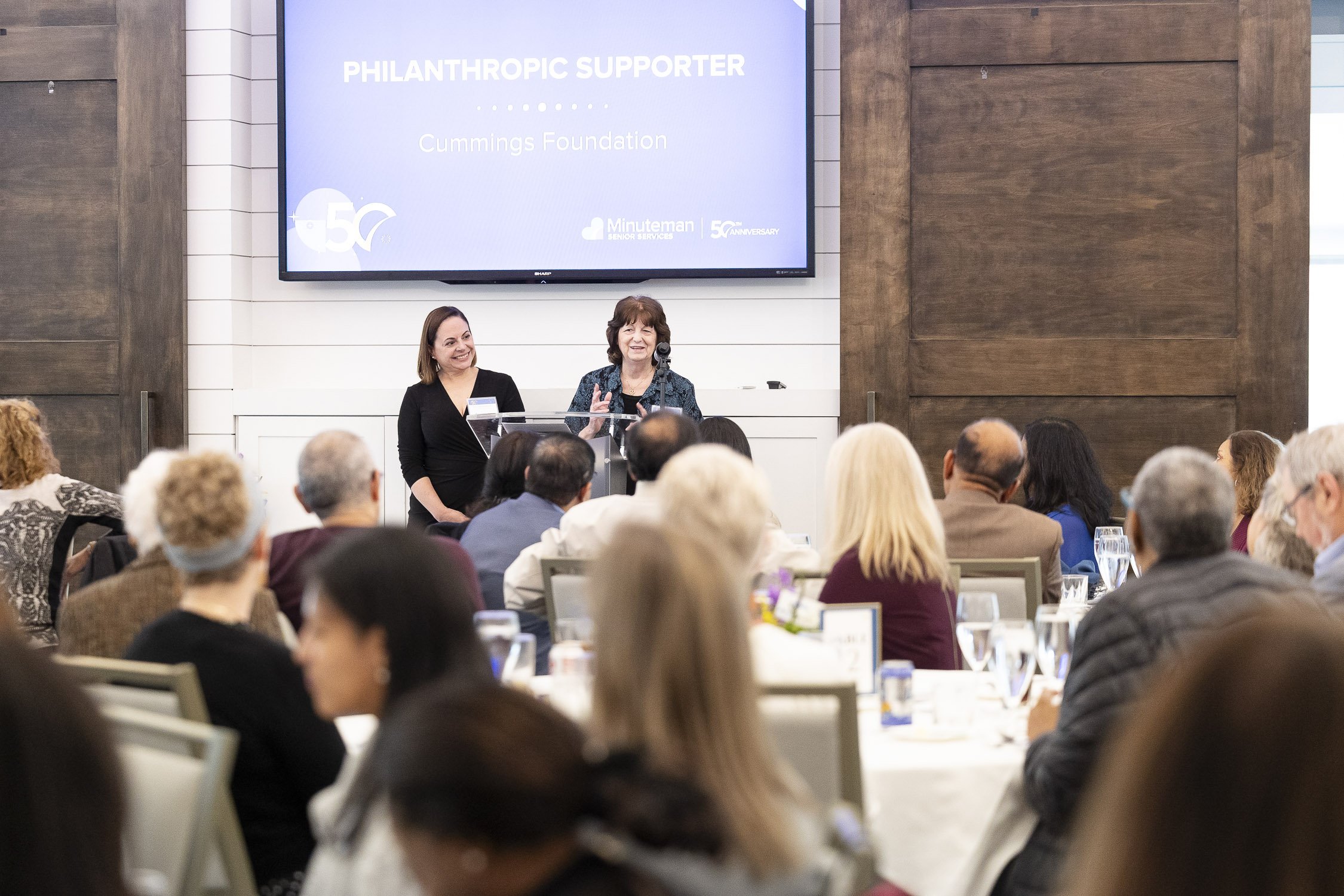 A woman speaking at a podium during a meeting in Lincoln, Massachusetts.
