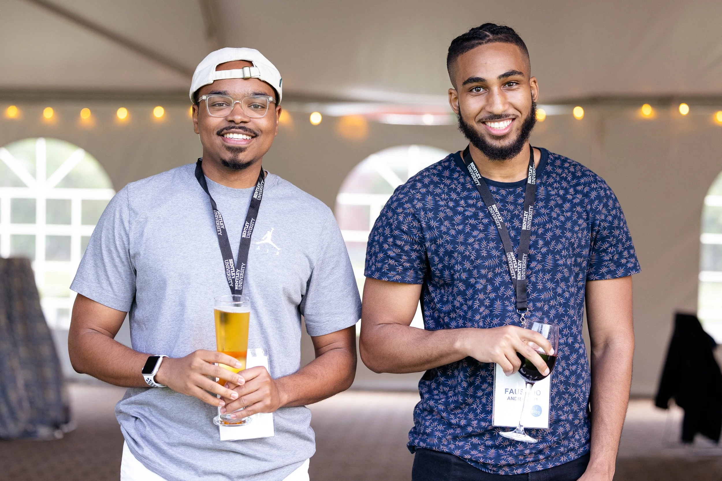 Two smiling young men at a social event at Bentley University.