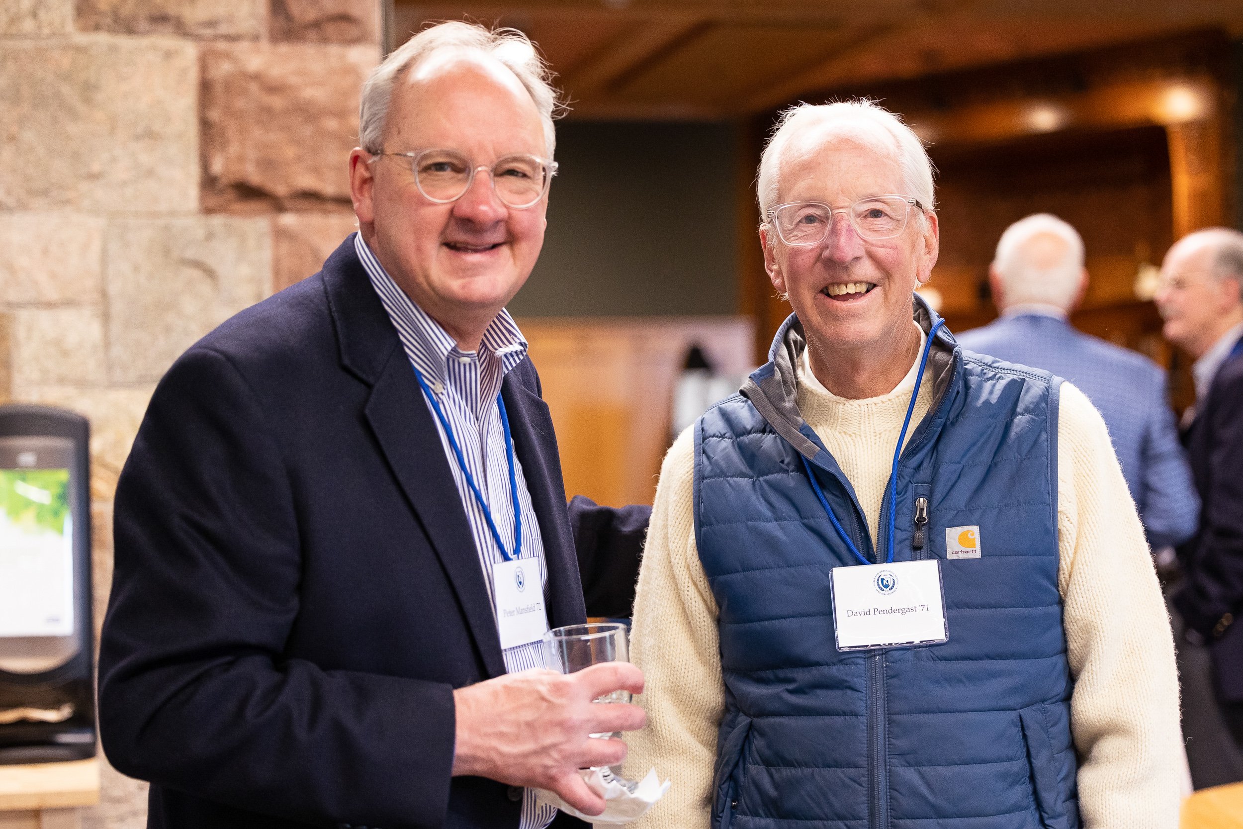 Two men smiling at an independent school social event in Massachusetts.