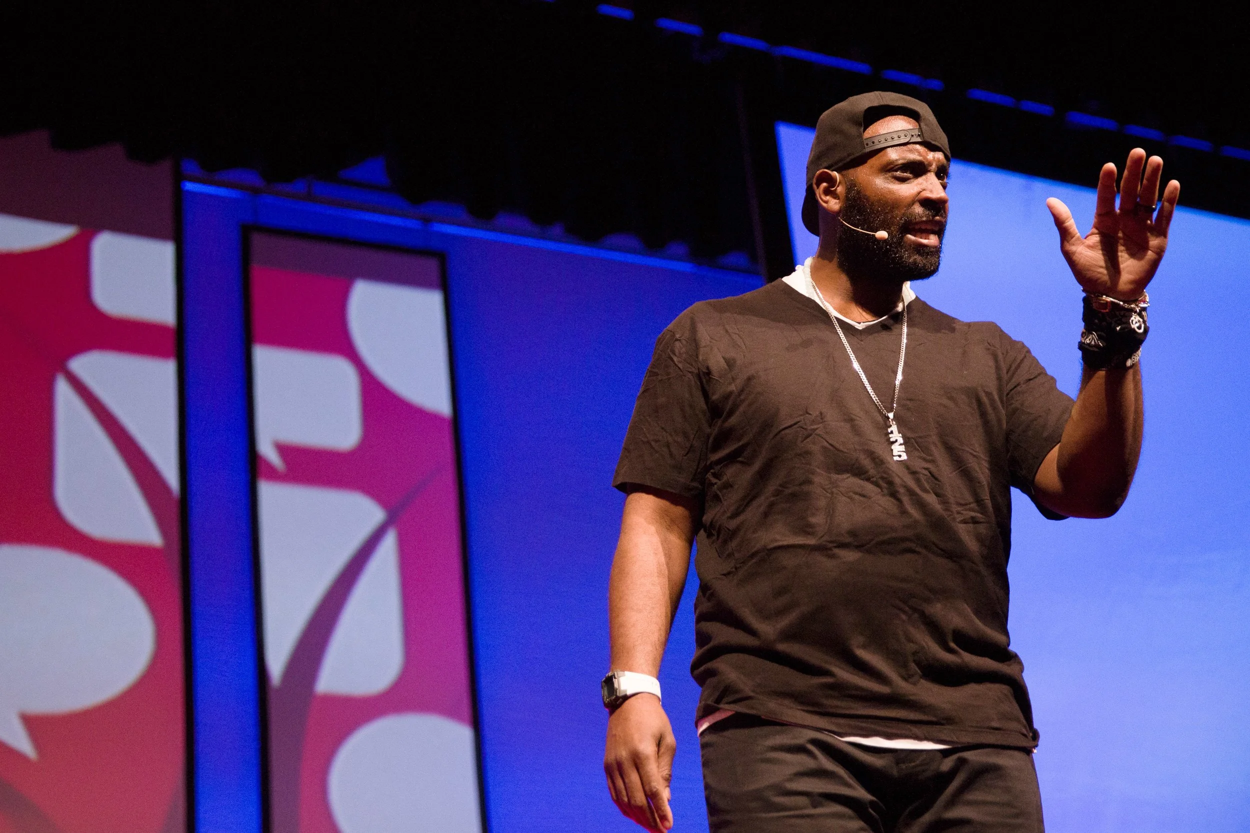 Man speaking on stage during TEDxNatick event.