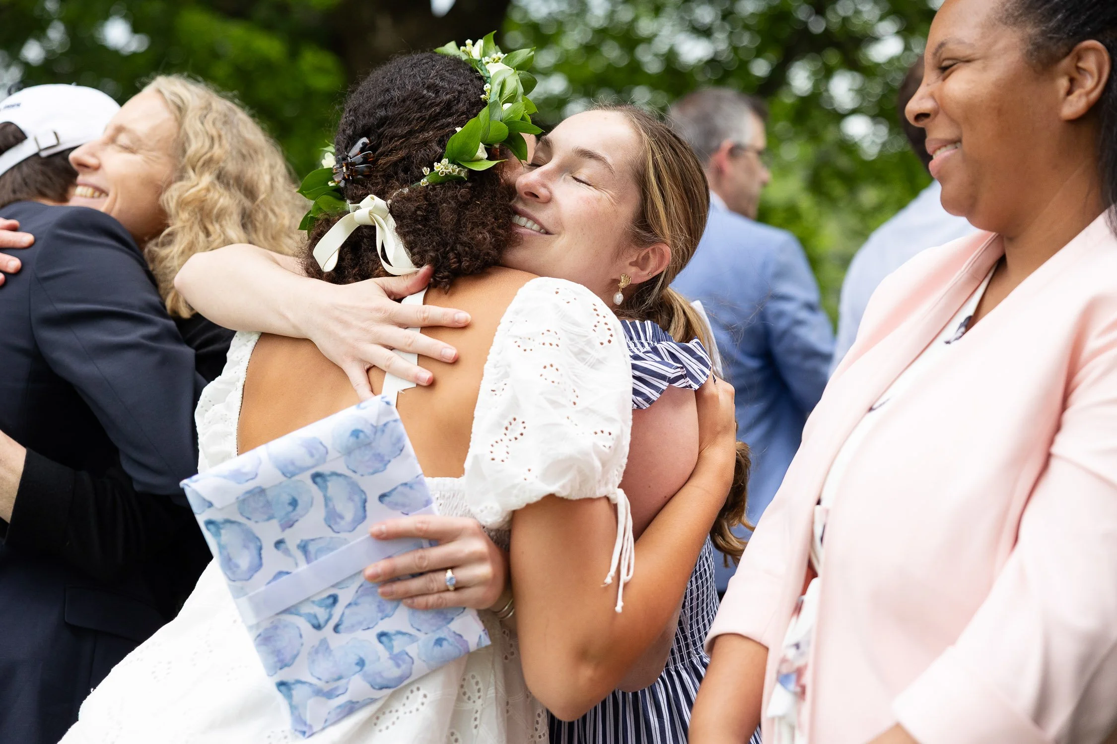 People hugging after an outdoor high school graduation.