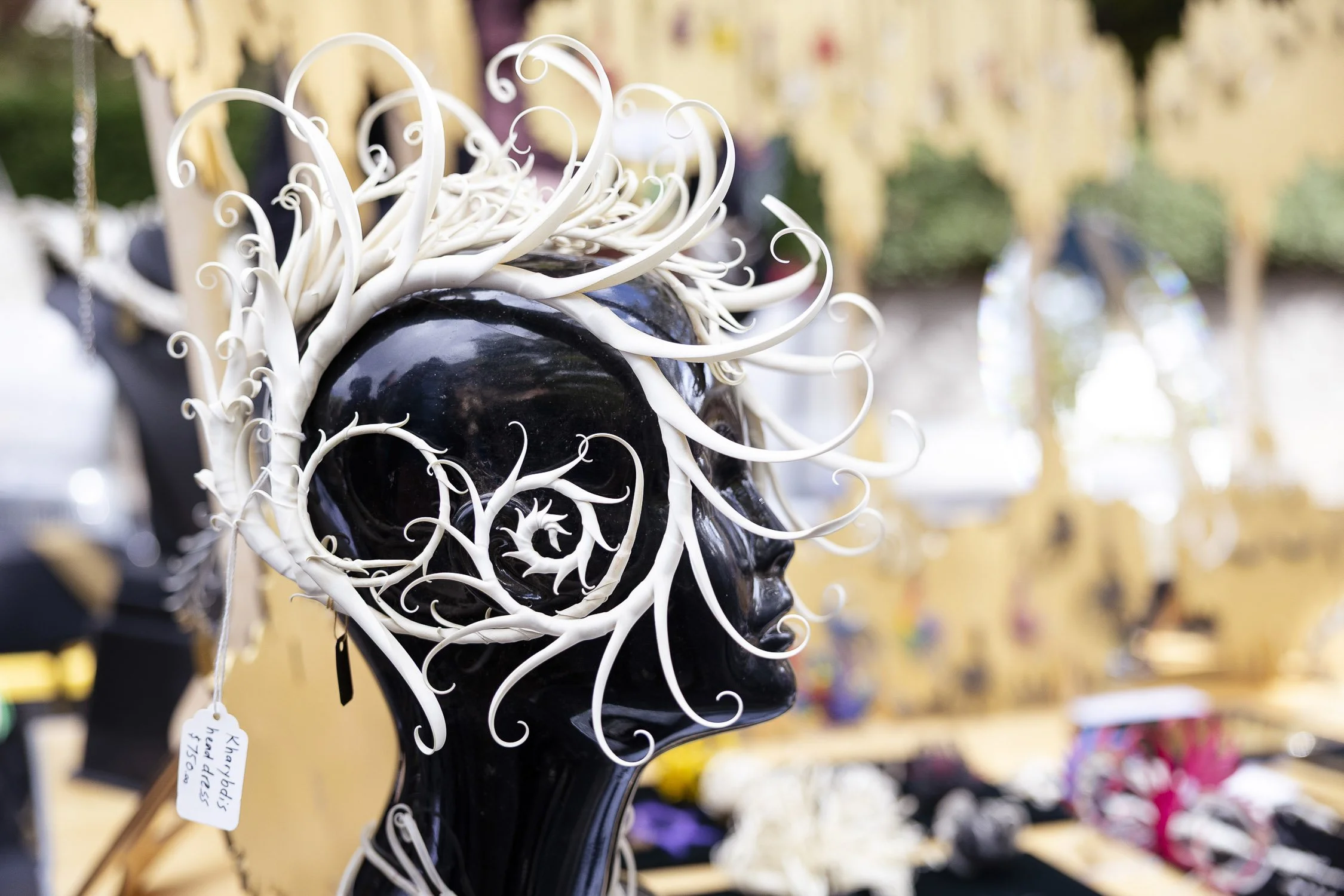 A black mannequin head with a white, swirling, decorative hairpiece on display at RISD Craft in Providence, Rhode Island.