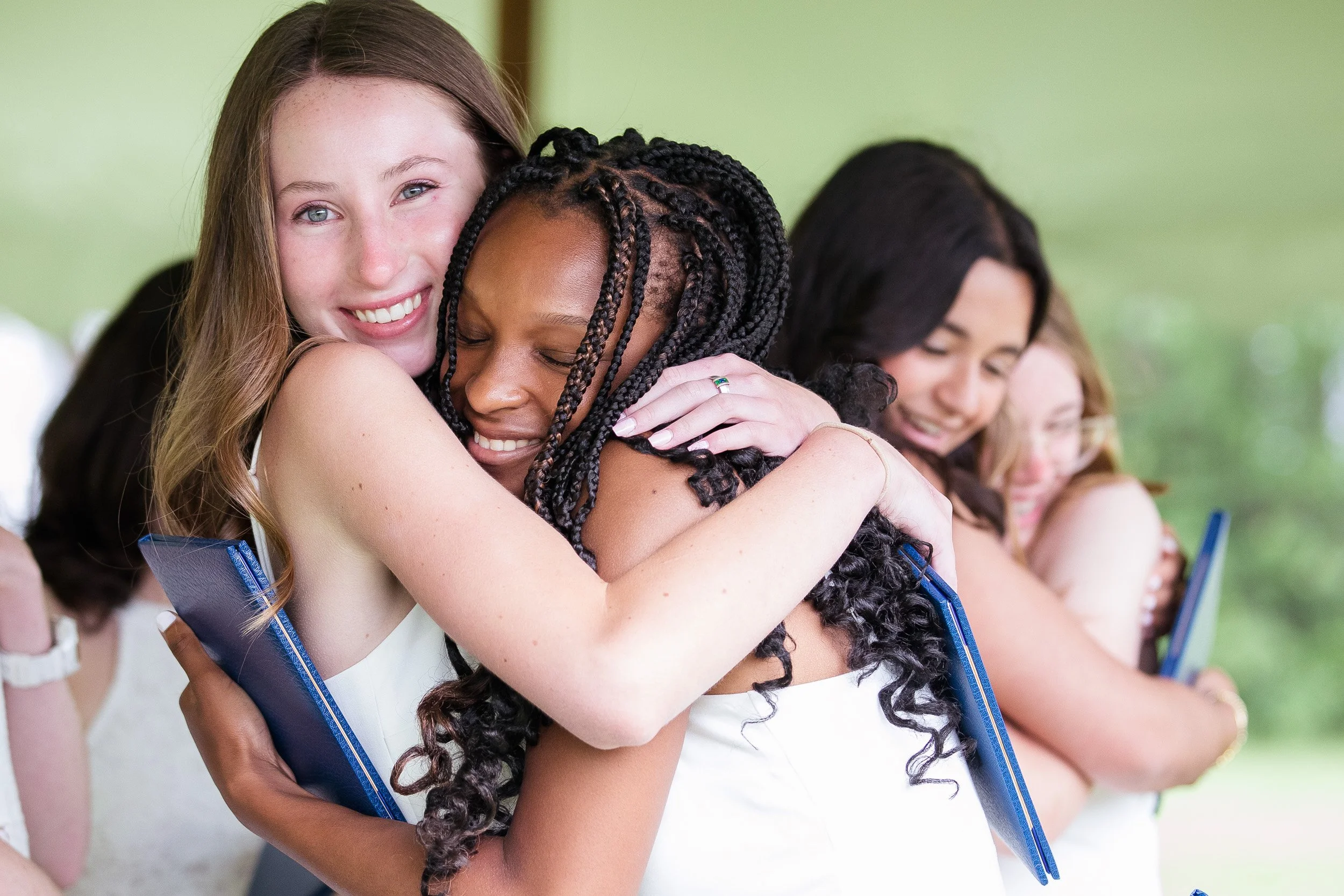 Group of middle school students embracing each other after graduation.