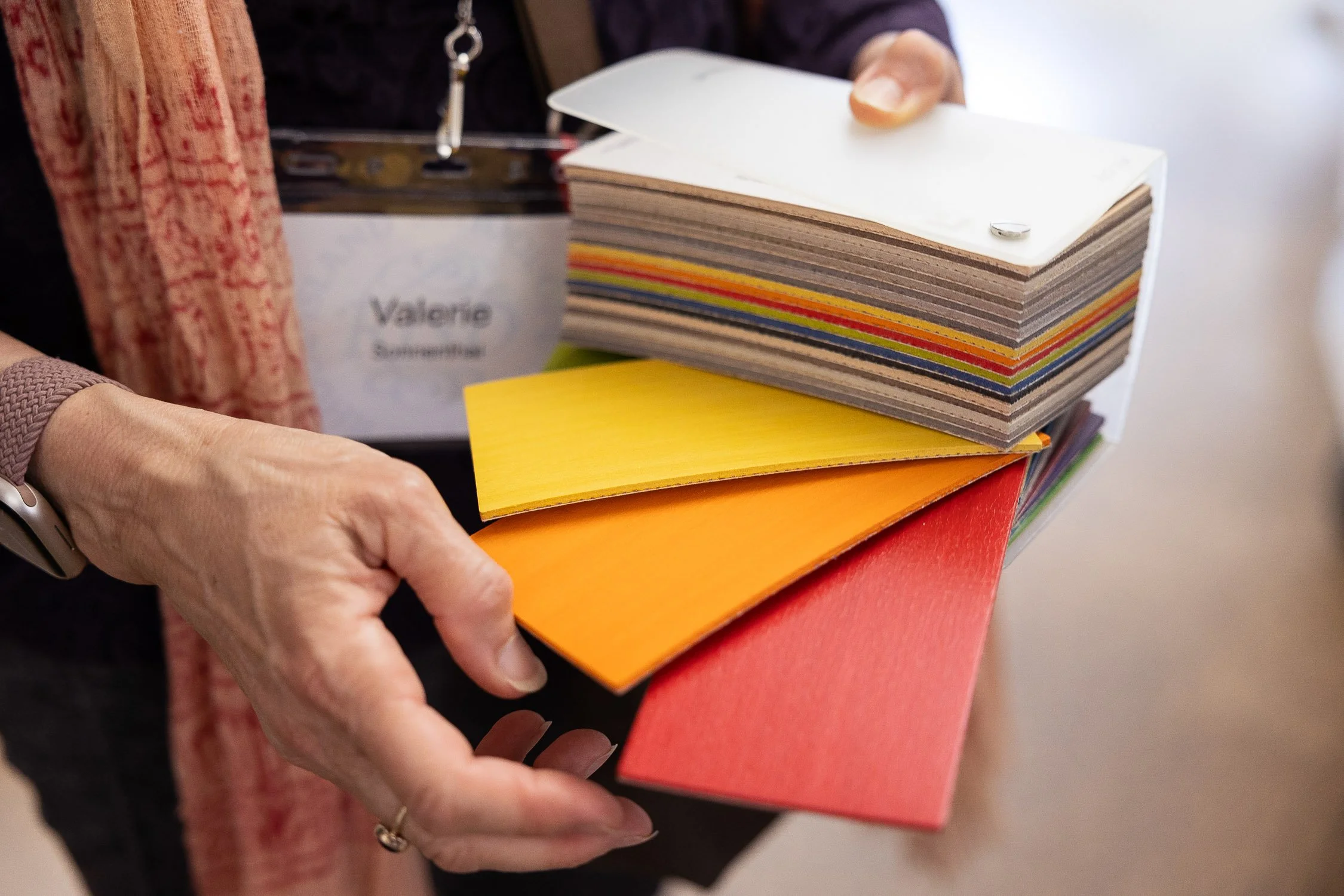 Close-up of a person's hand holding a stack of color samples.