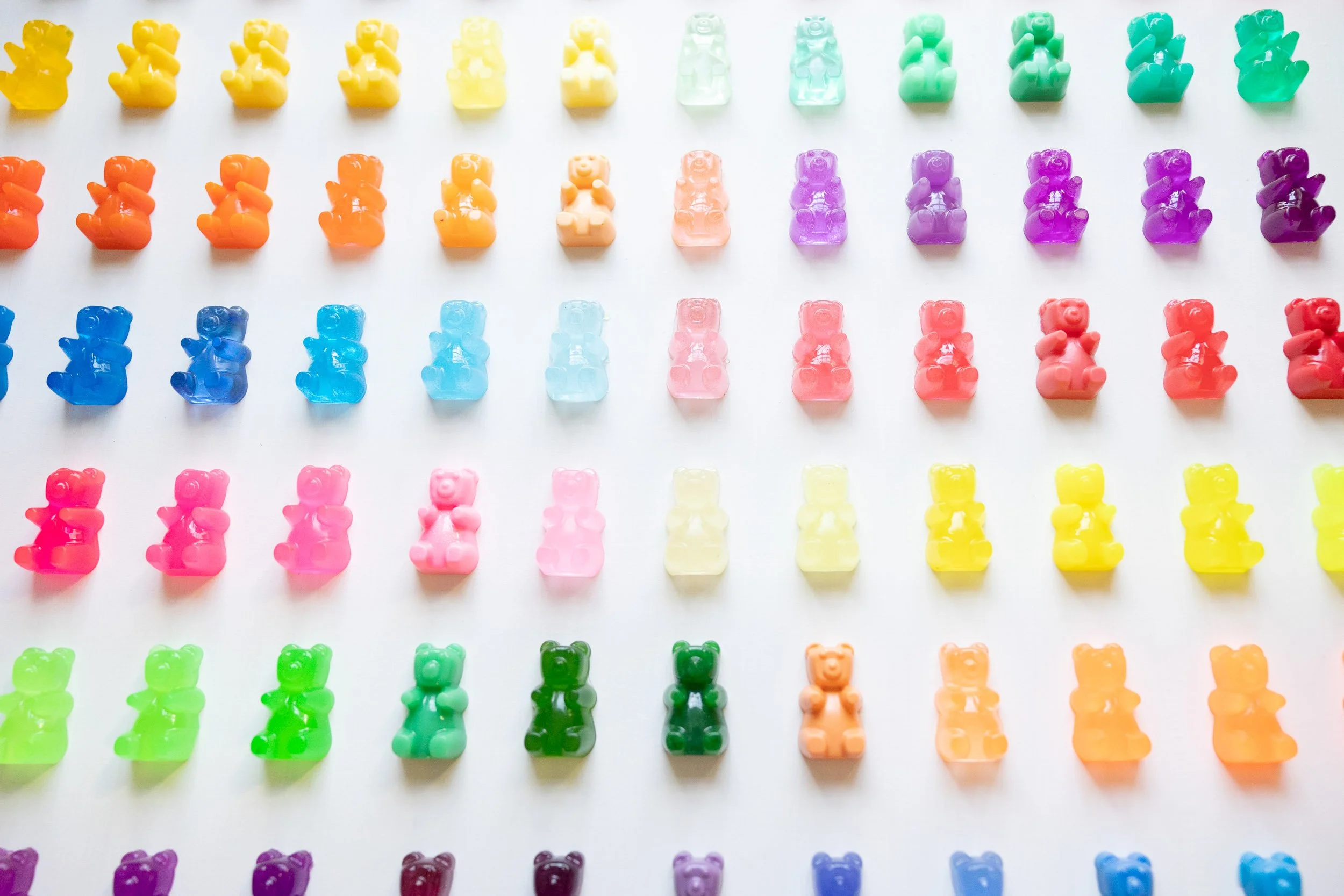 Colorful resin gummy bear artwork on white background.