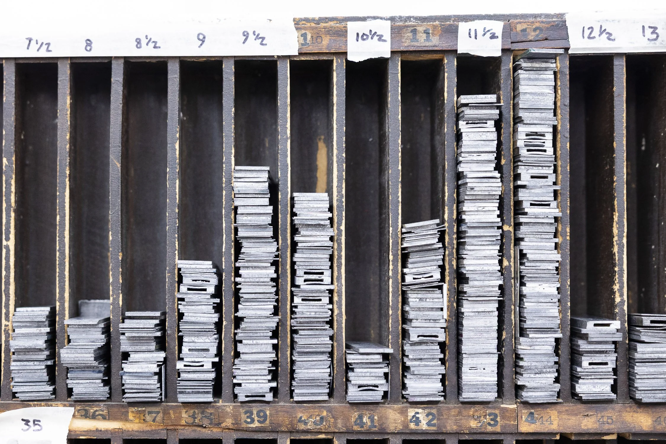 Vintage metal compartments filled with metal types organized by size.
