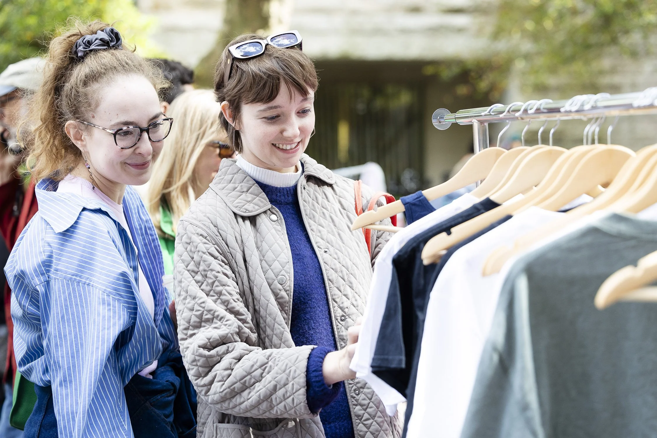 Two women shopping outdoors at a clothing rack at RISD Craft in Providence, Rhode Island.