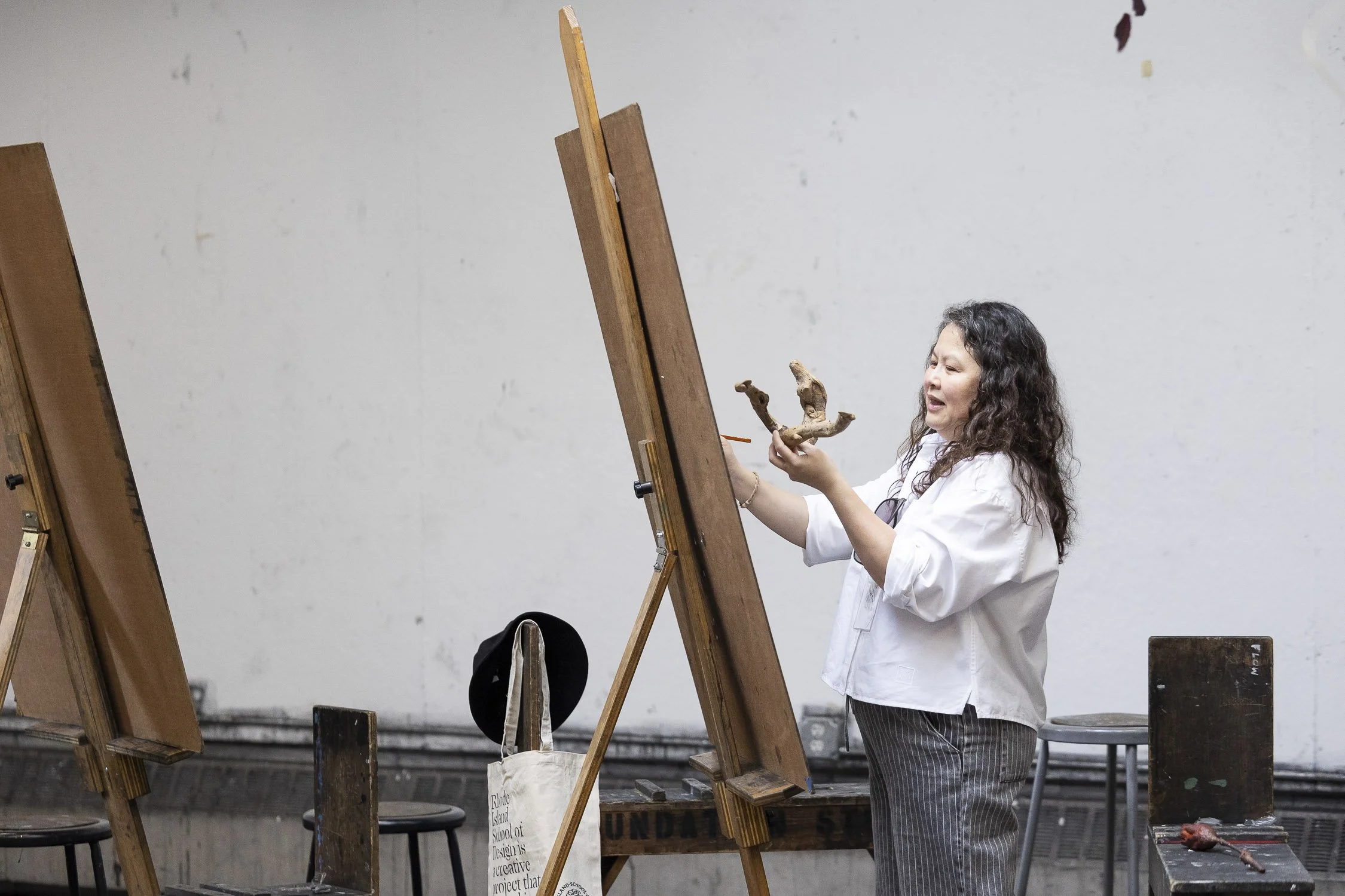 A woman a drawing a piece of antler on an easel in an art studio at RISD.