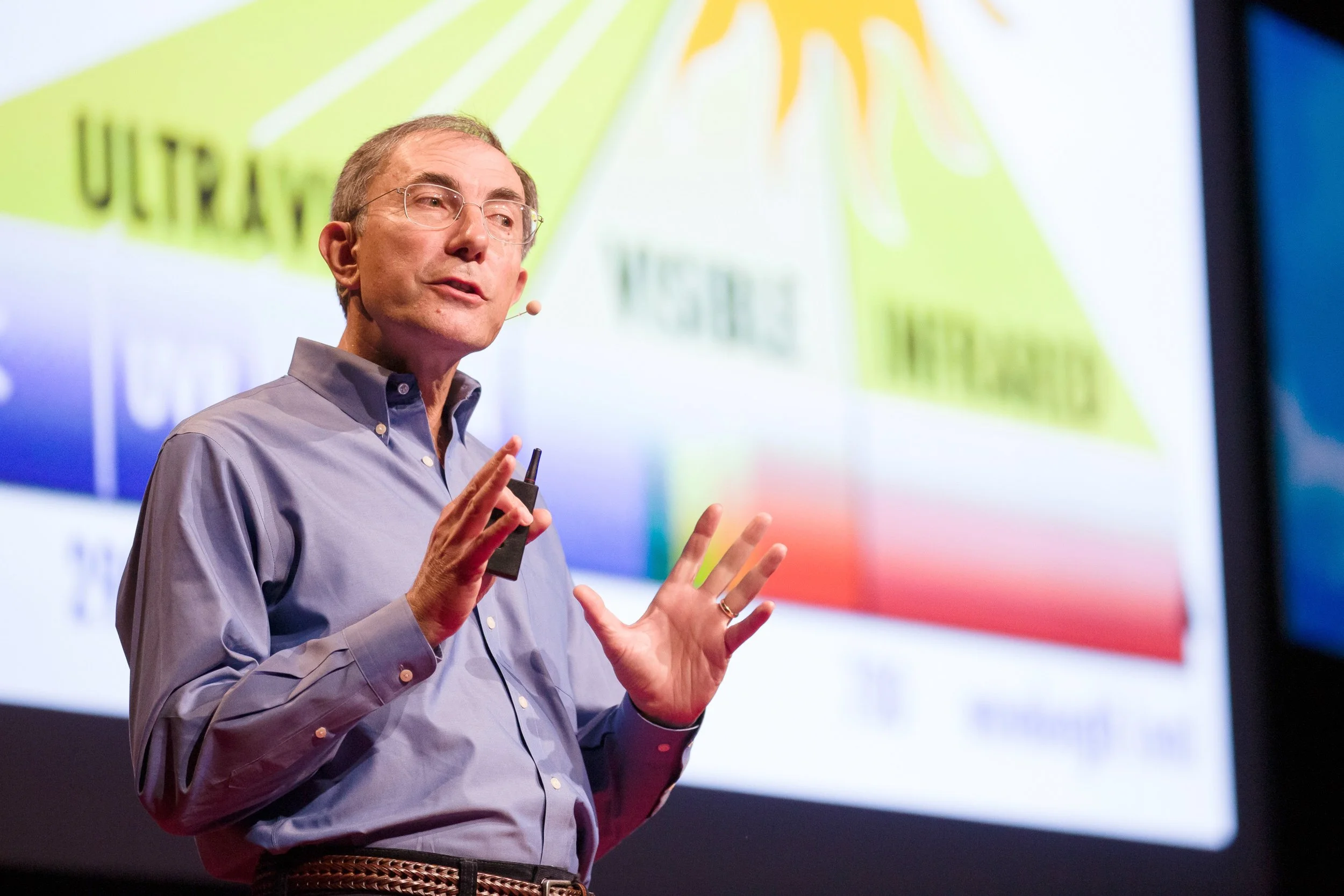 Man giving a TEDx talk in front of a colorful chart in Boston, Massachusetts.