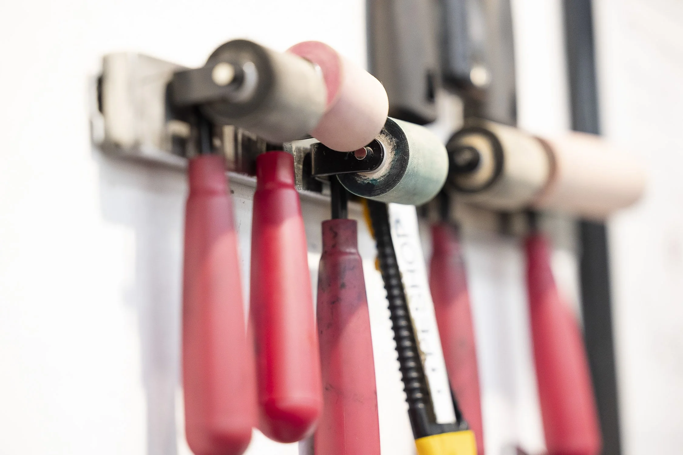 A close-up view of a rack with various printmaking tools.