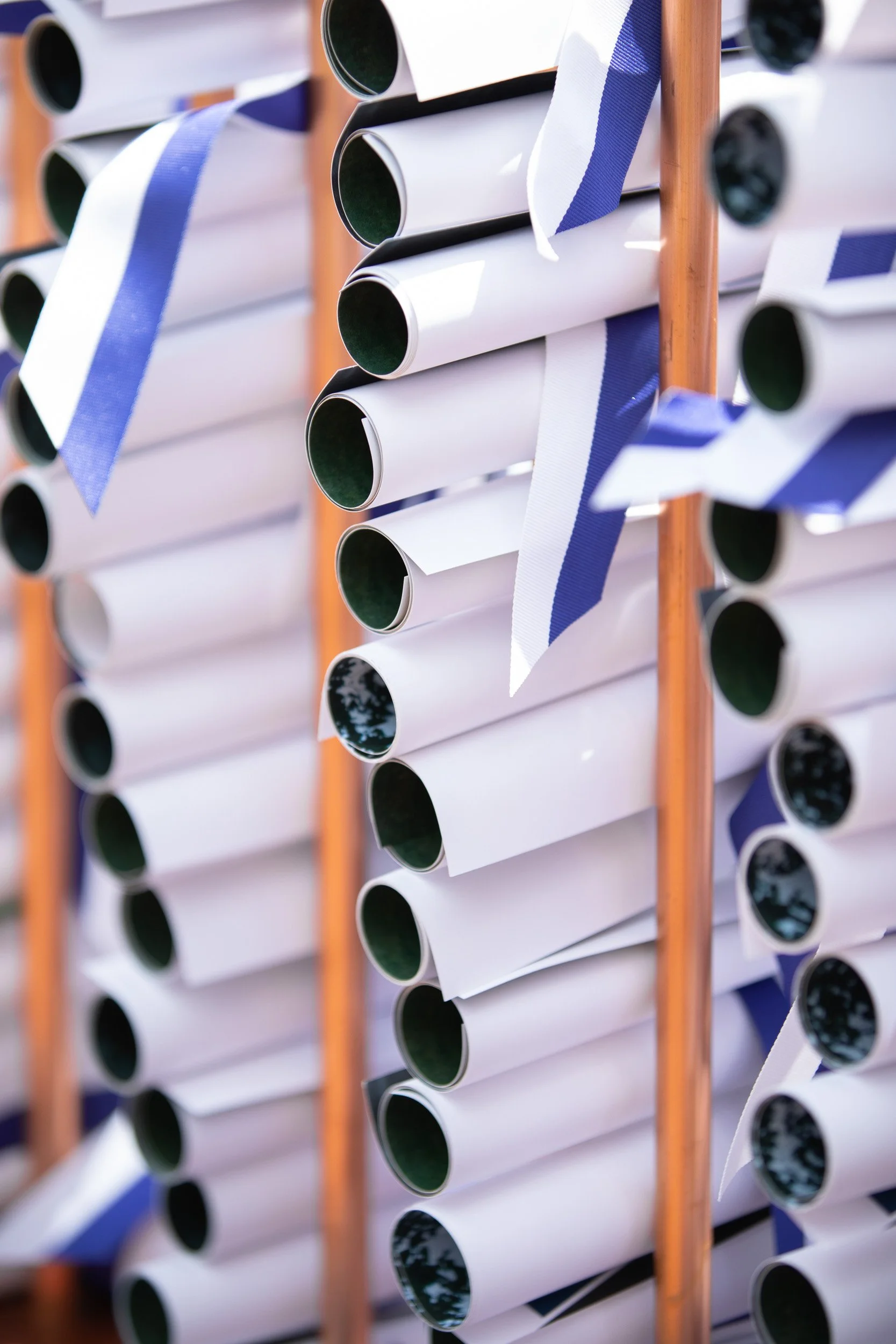Rows of rolled-up graduation diplomas.