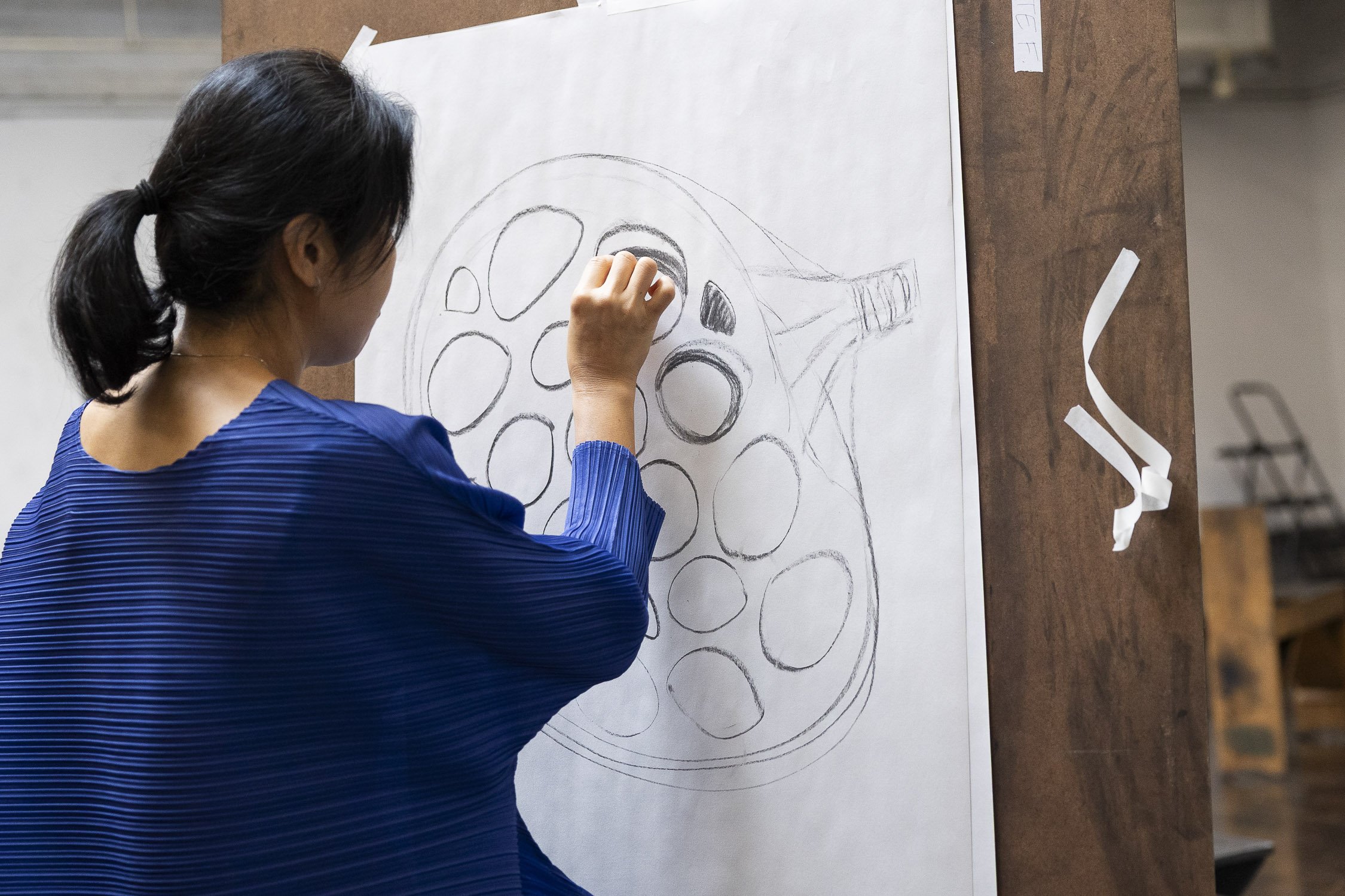Woman drawing at an easel during an art workshop in Rhode Island.