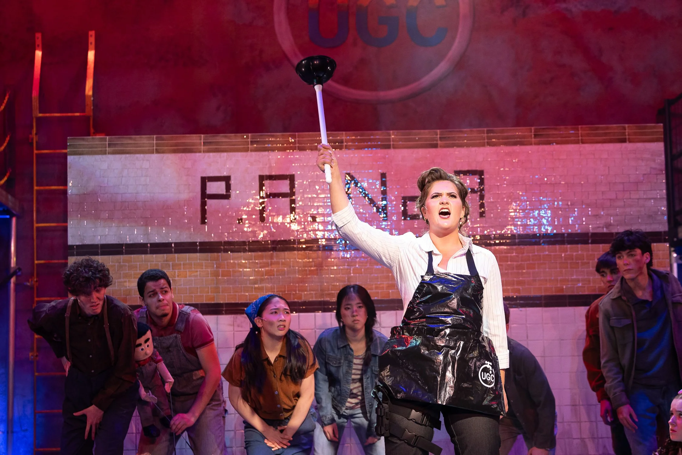 Student Holding Plunger in High School Production of Urinetown