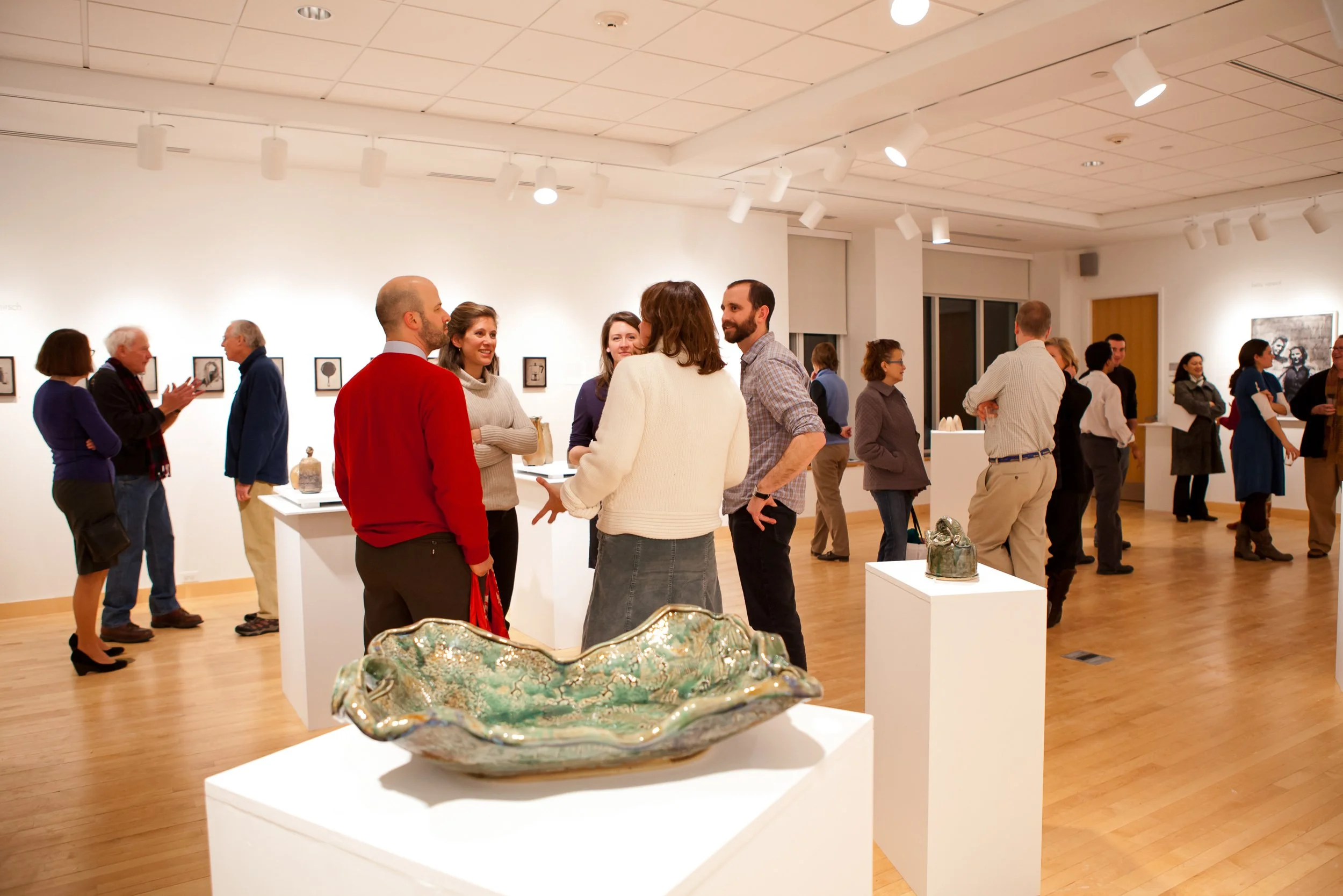 People attending an art gallery exhibition at Dexter-Southfield School.