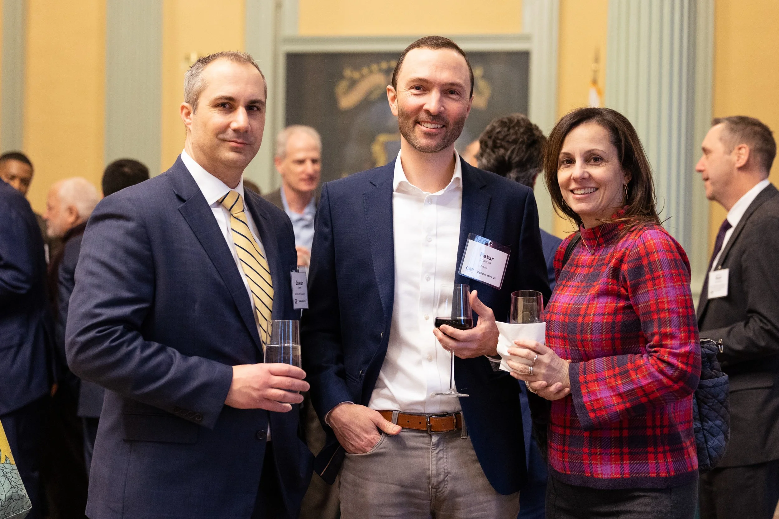 Three people at a networking event at the Massachusetts State House in Boston.