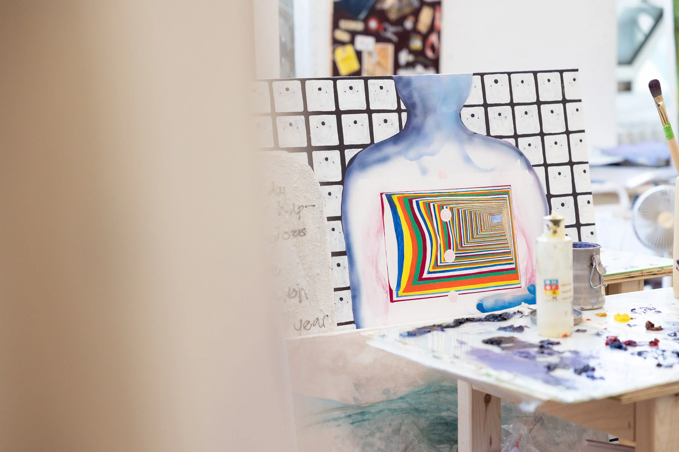 An art studio scene with a colorful abstract painting.