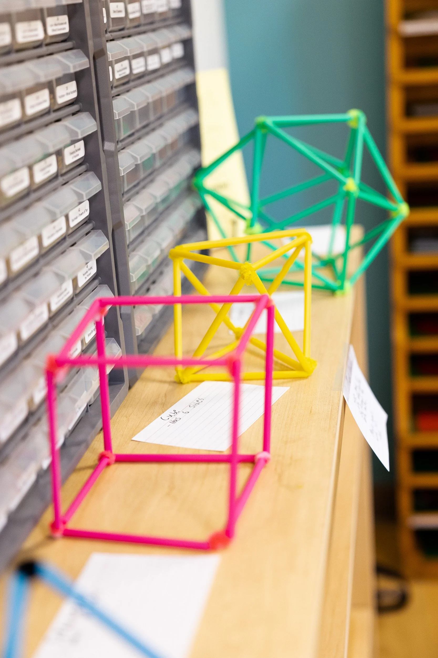 Colorful geometric construction sets on a wooden table in a Montessori classroom.
