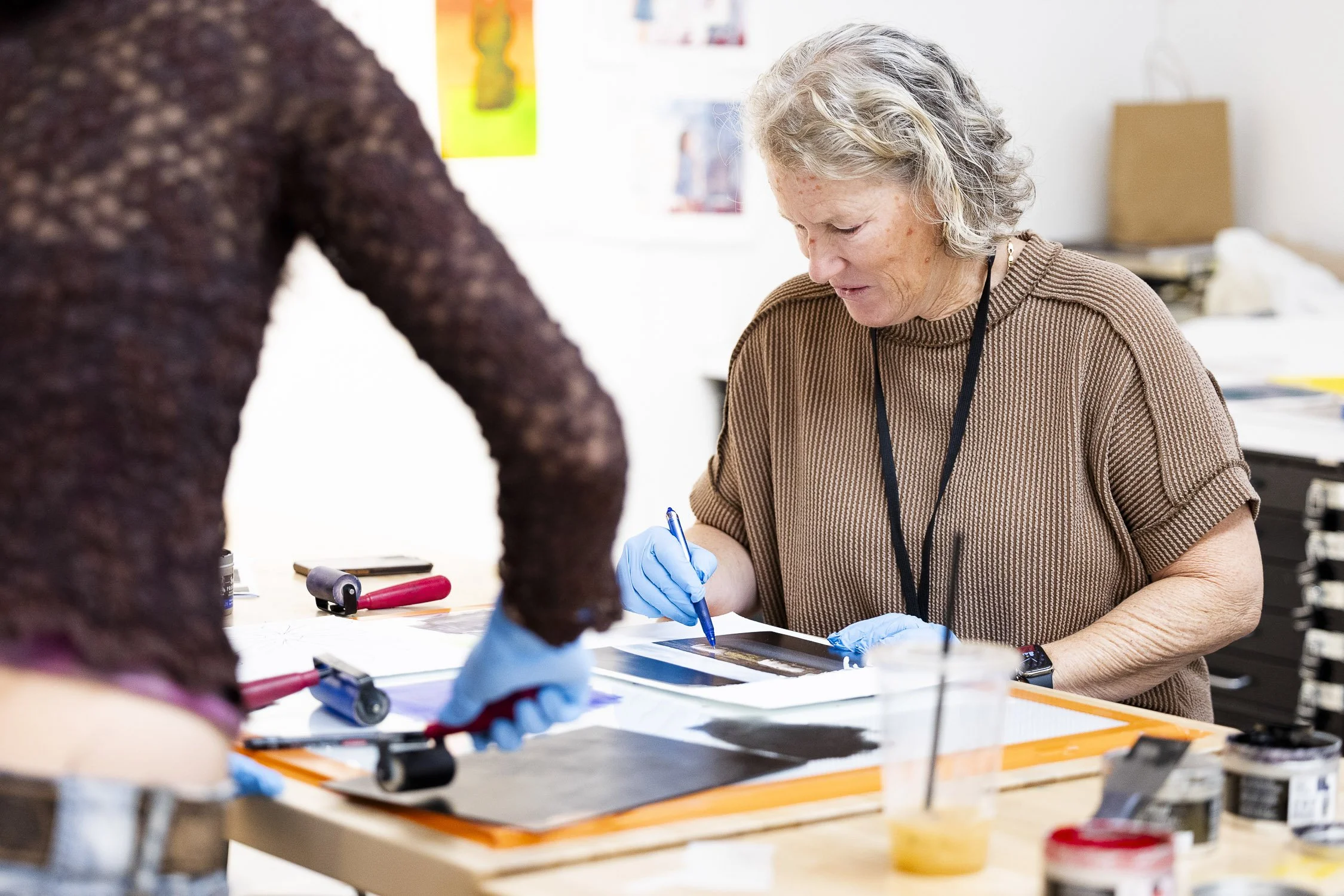 An woman working on a print in an art studio during a class at a Boston art school.